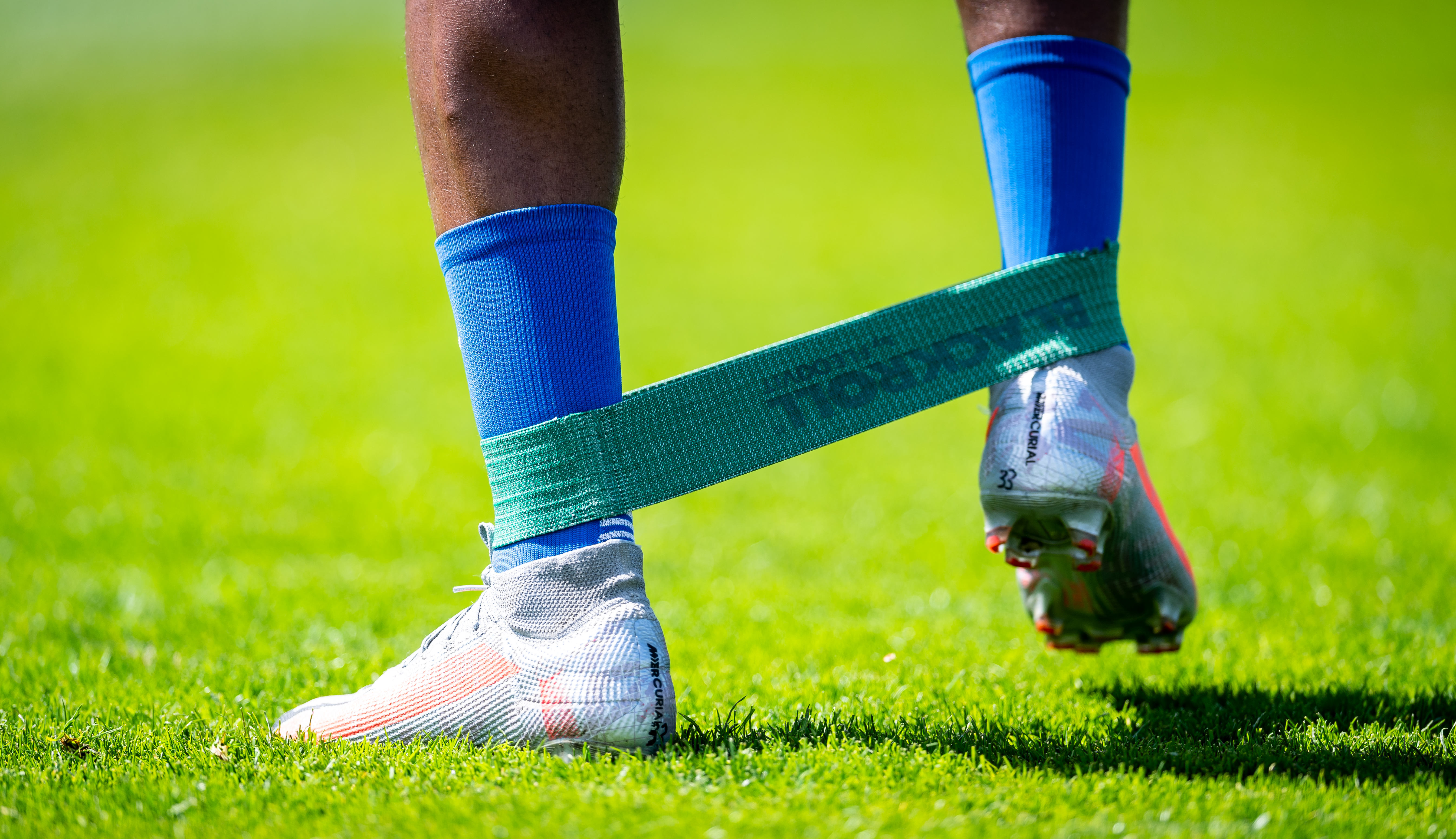 Close up of football boots and a resistance band being worn by a Hertha BSC player.