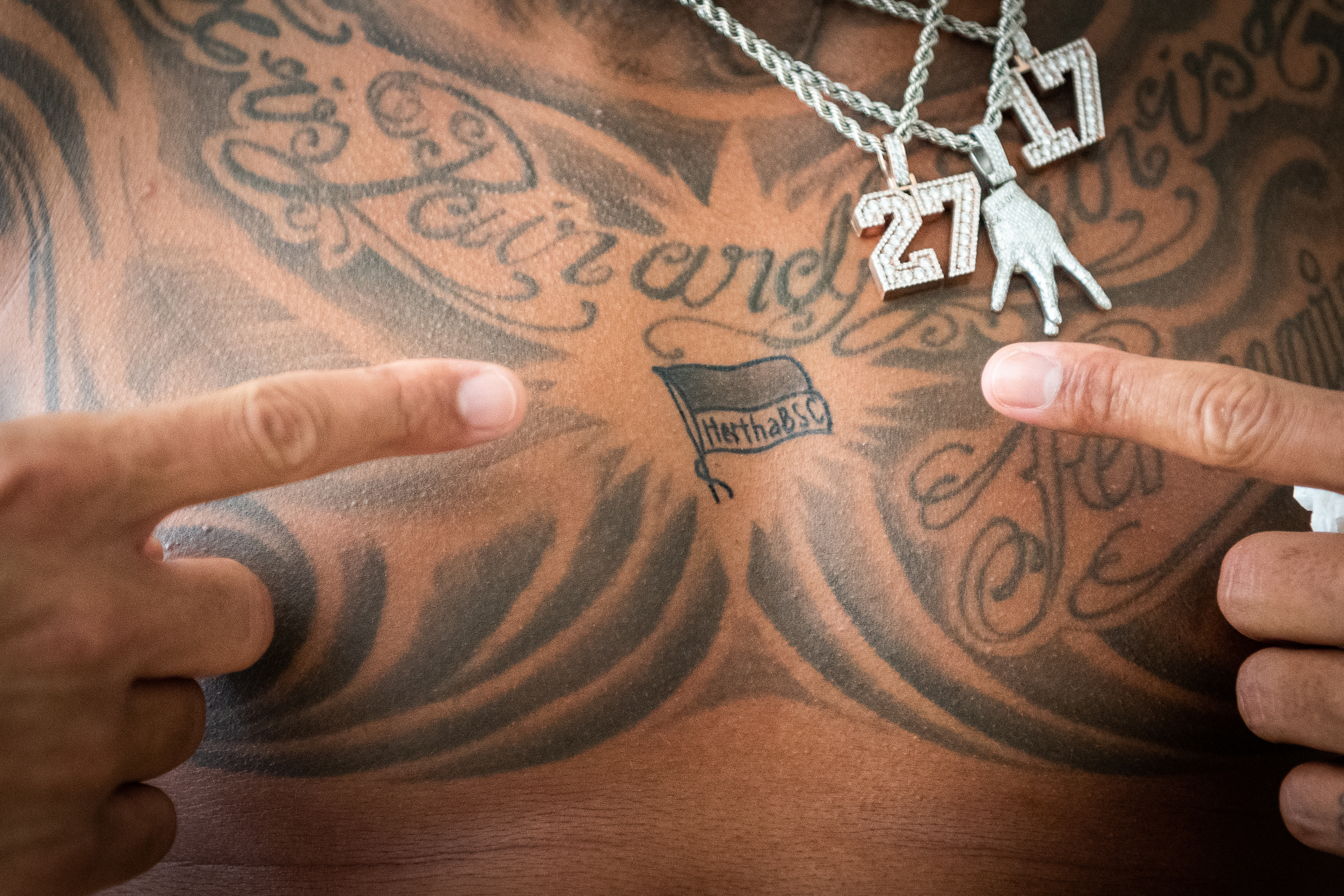 Prince Boateng zeigt auf sein Tattoo auf der Brust.