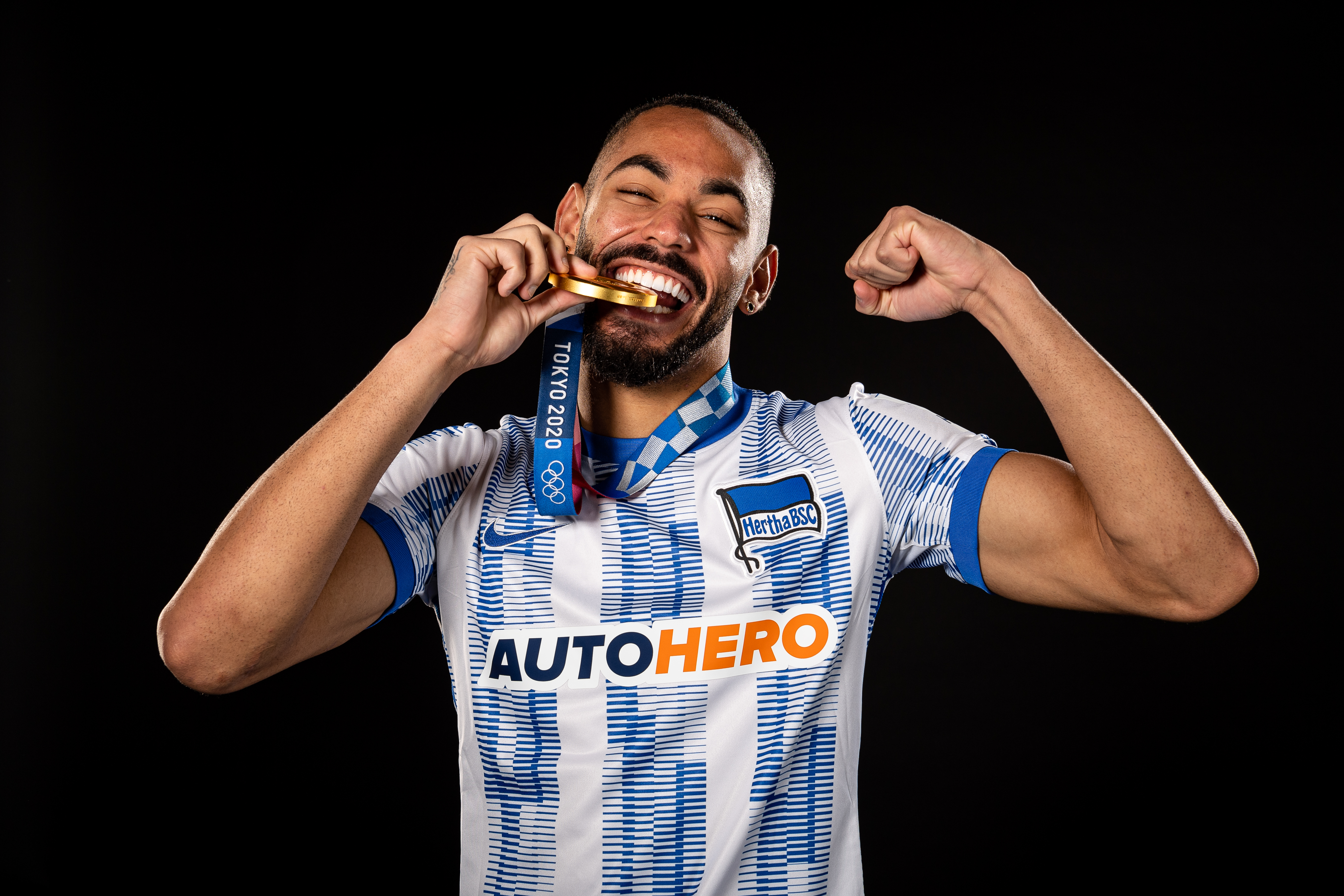 Matheus Cunha shows off his gold medal in the Hertha kit.