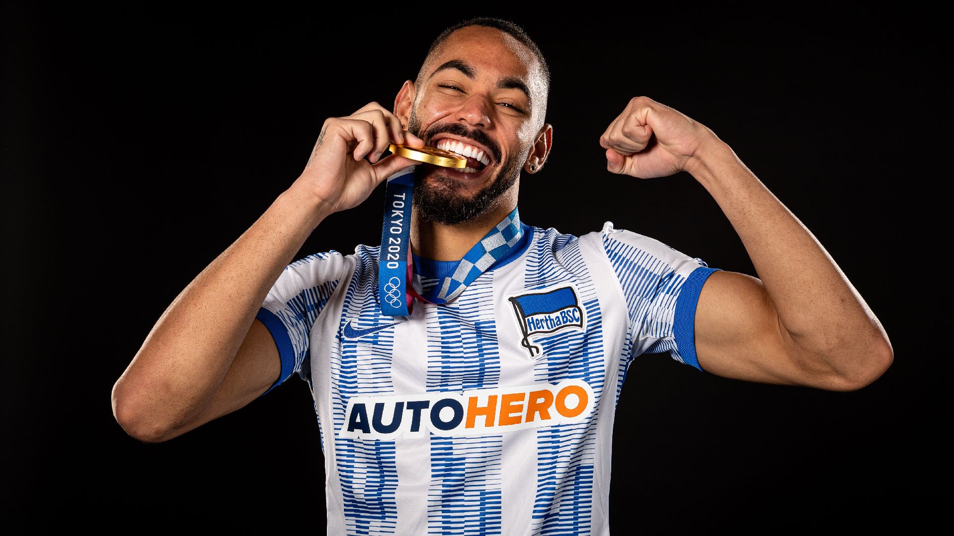 Matheus Cunha shows off his gold medal in the Hertha kit.