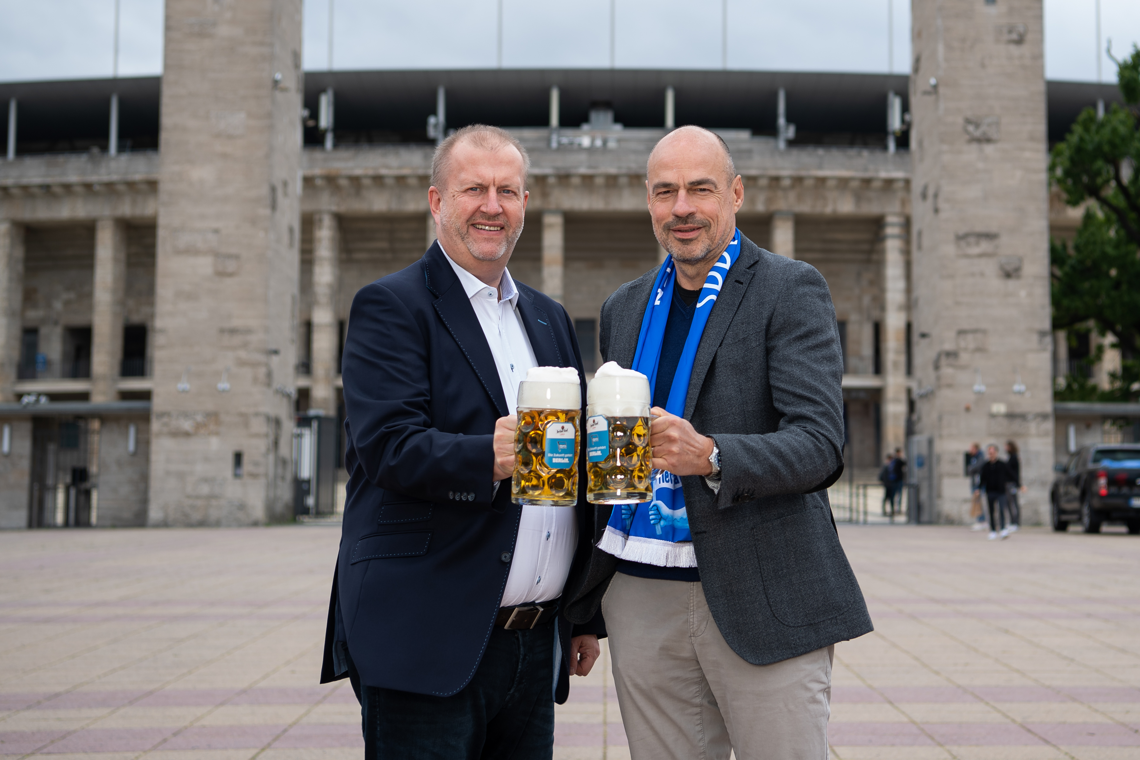 Ingo Schiller (li.) und Wolfhard Buß mit Biergläsern vor dem Olympiastadion.