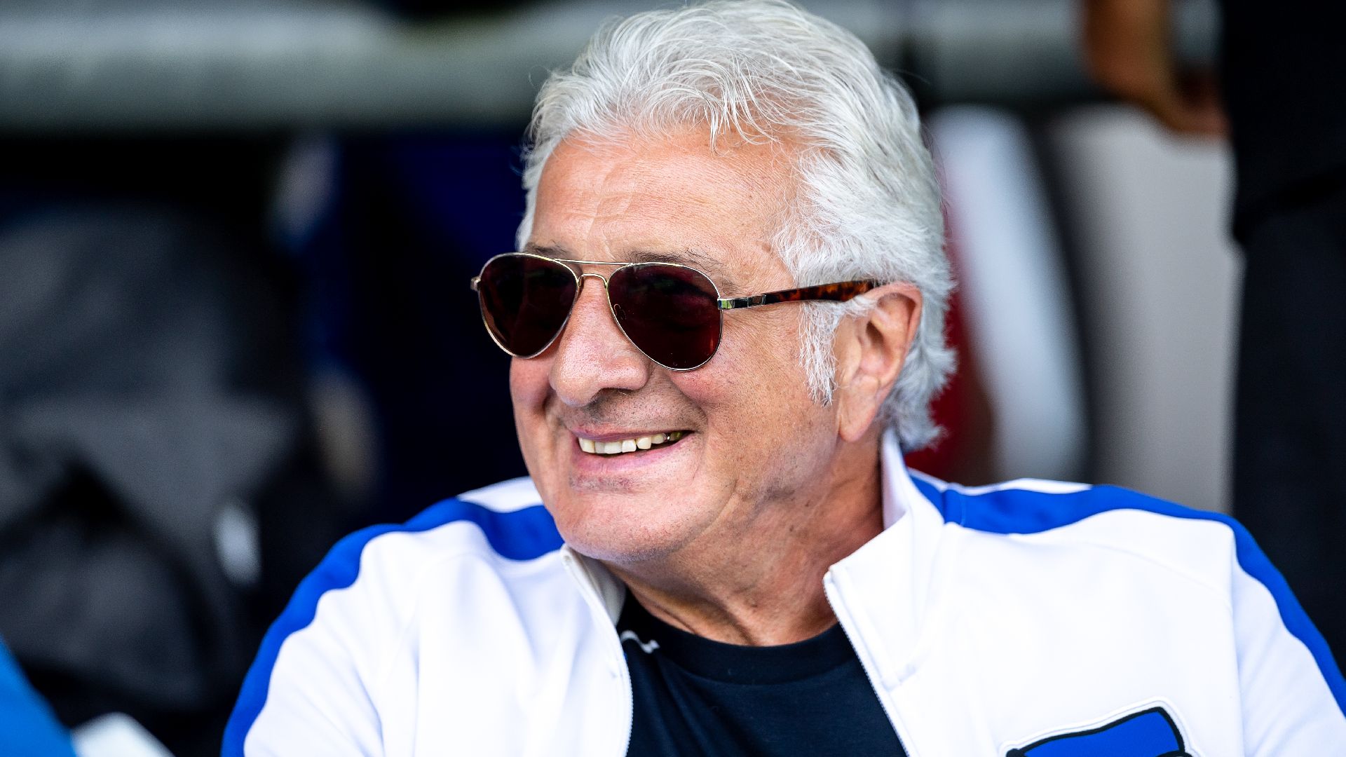 Nello di Martino sitzt auf der Tribüne und lächelt.