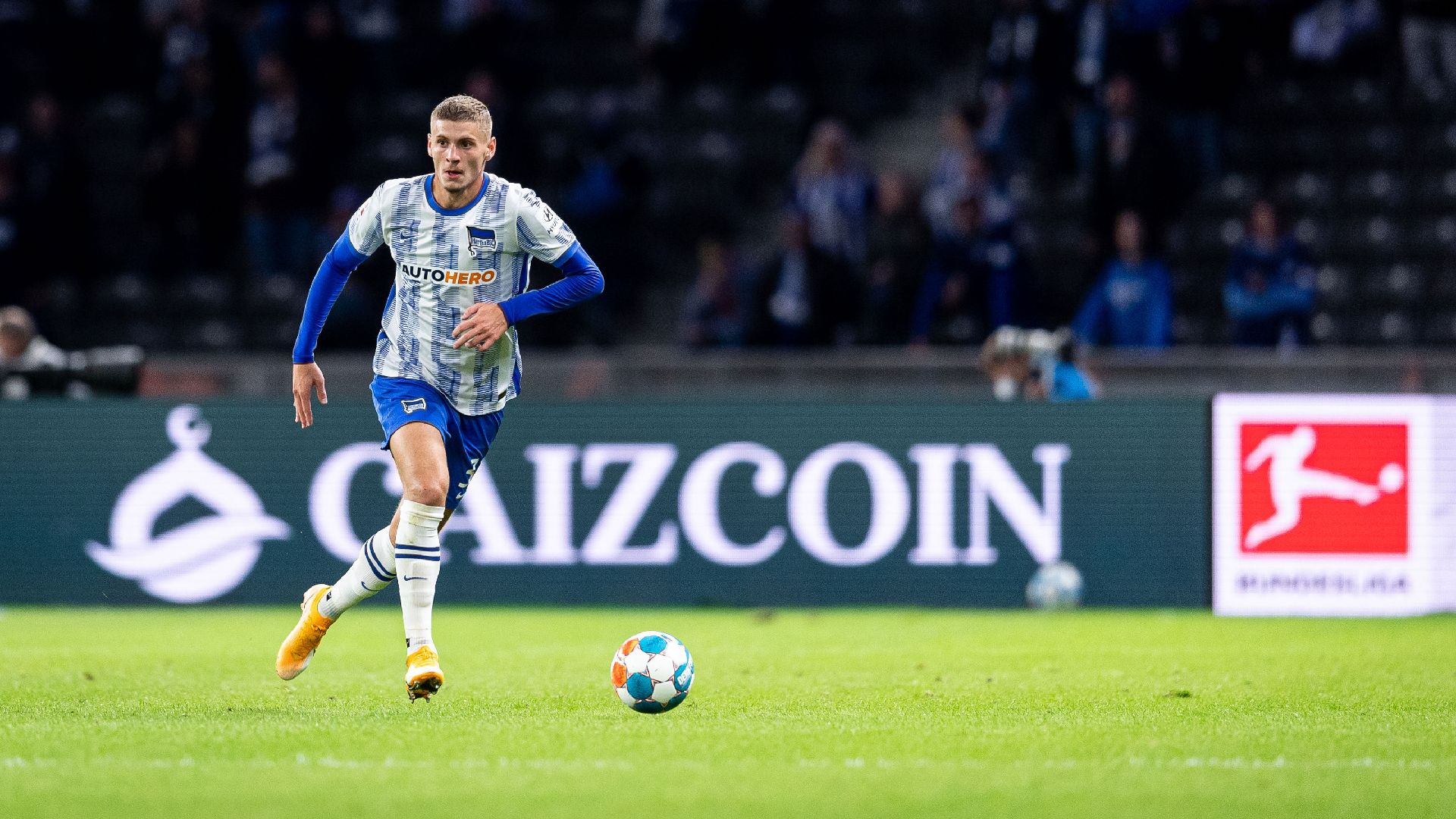Márton Dárdai führt den Ball, im Hintergrund sieht man eine Caizcoin-Bandenwerbung.