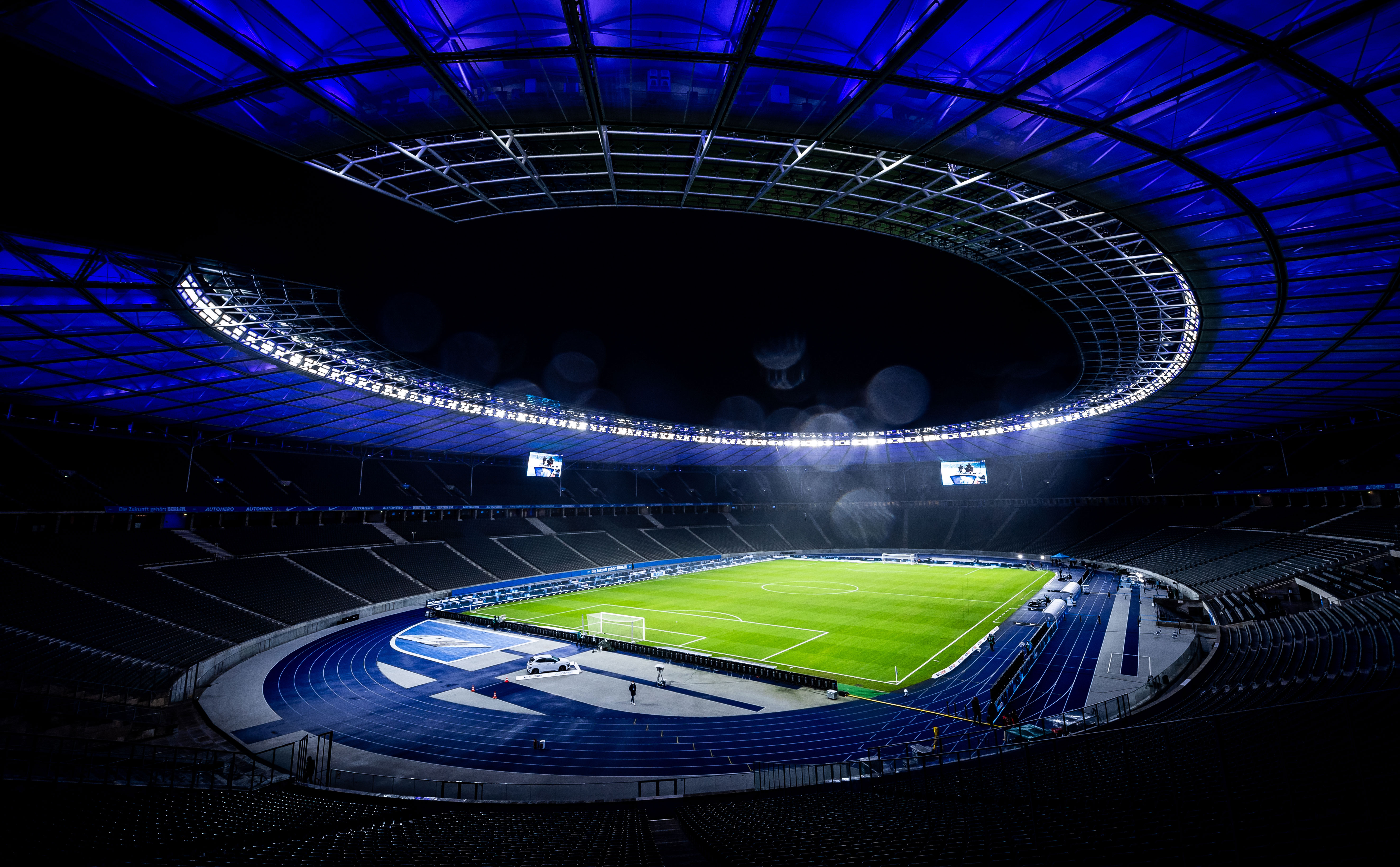 Das Olympiastadion bei Nacht mit blauer Beleuchtung.