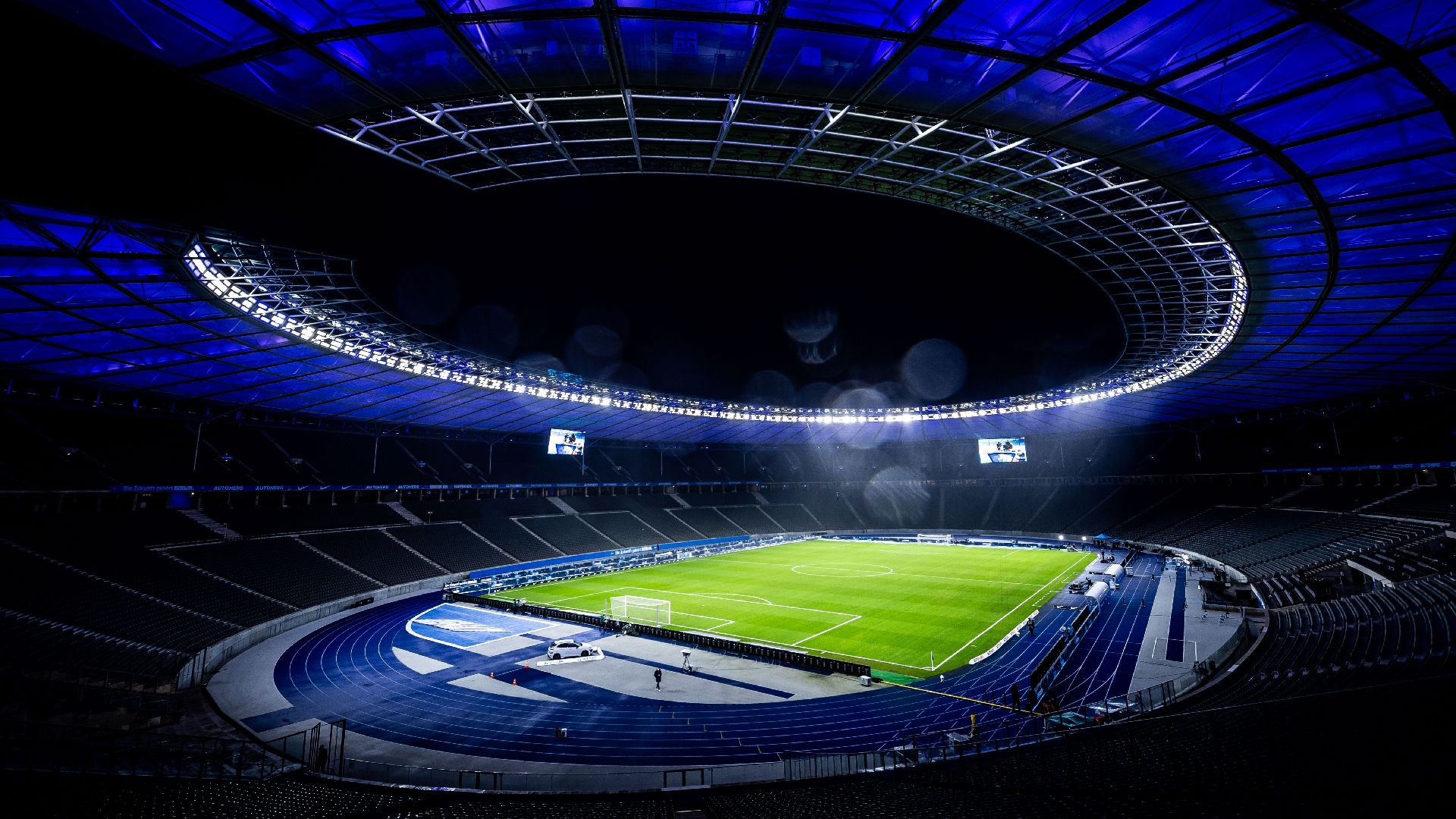 Das Olympiastadion bei Nacht mit blauer Beleuchtung.