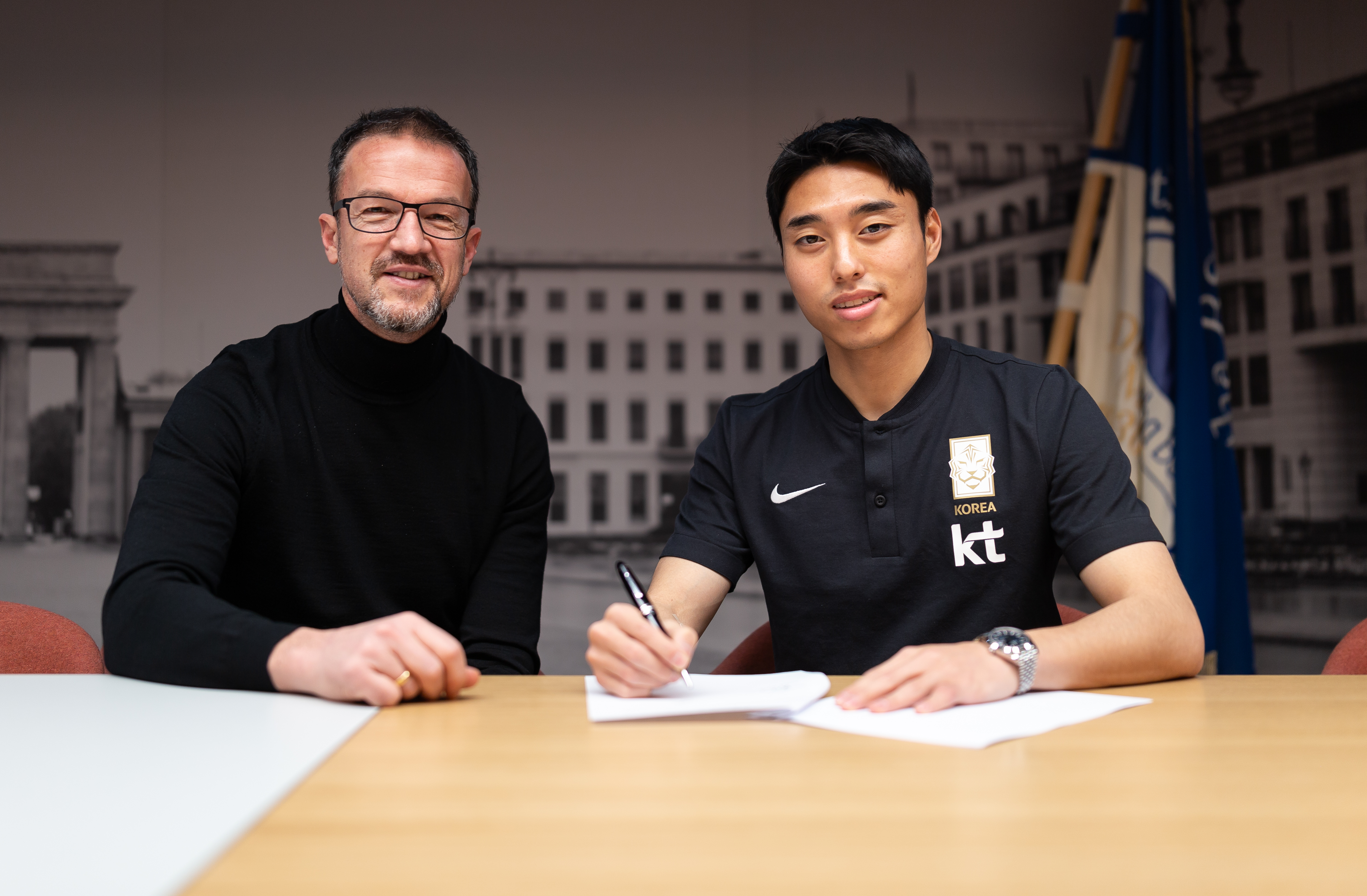 Dogjun Lee (right) signs his contract alongside Fredi Bobic.