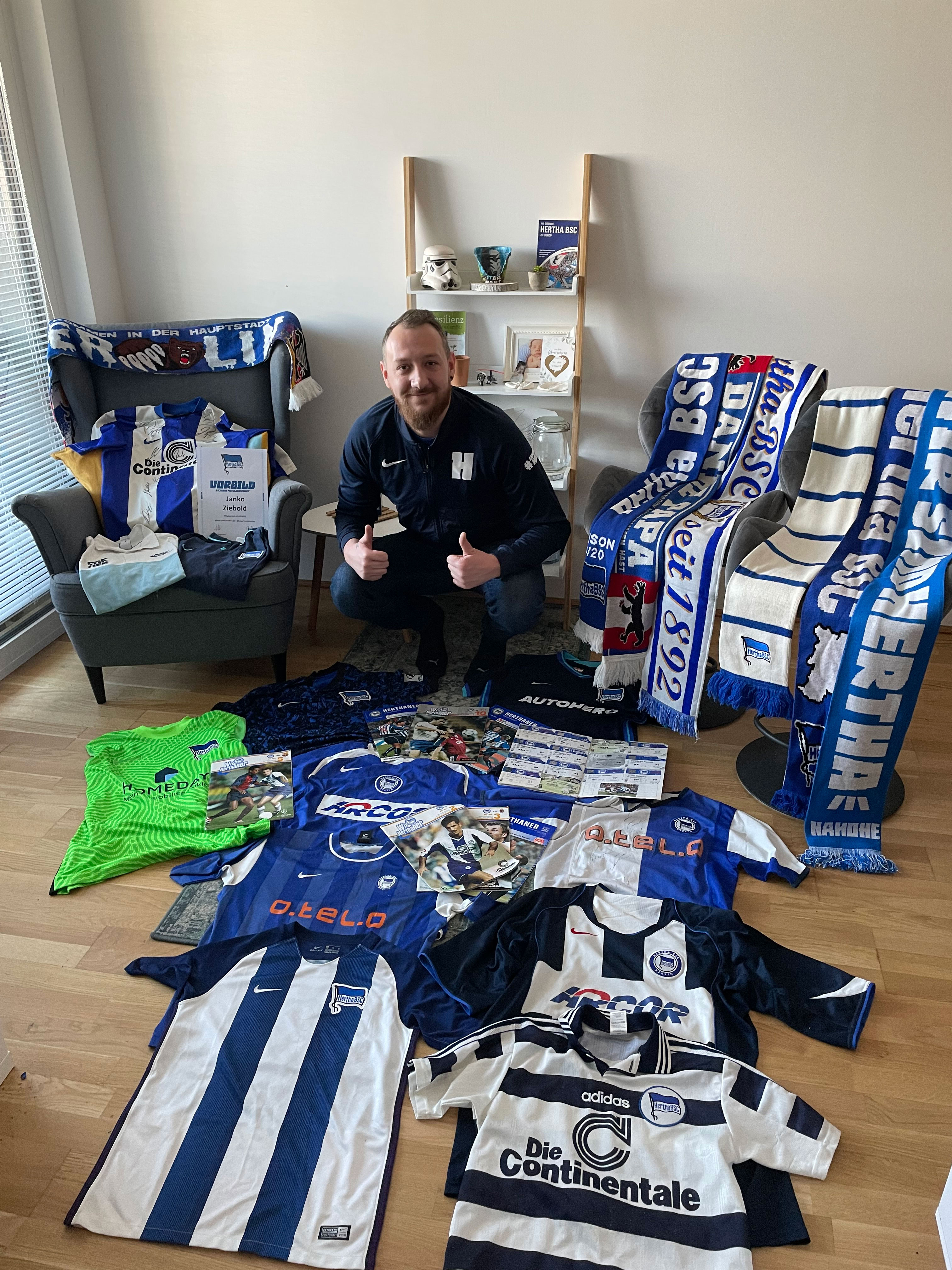 Exil-Herthaner Janko Ziebold posiert in seinem Wohnzimmer mit den Hertha-Utensilien.