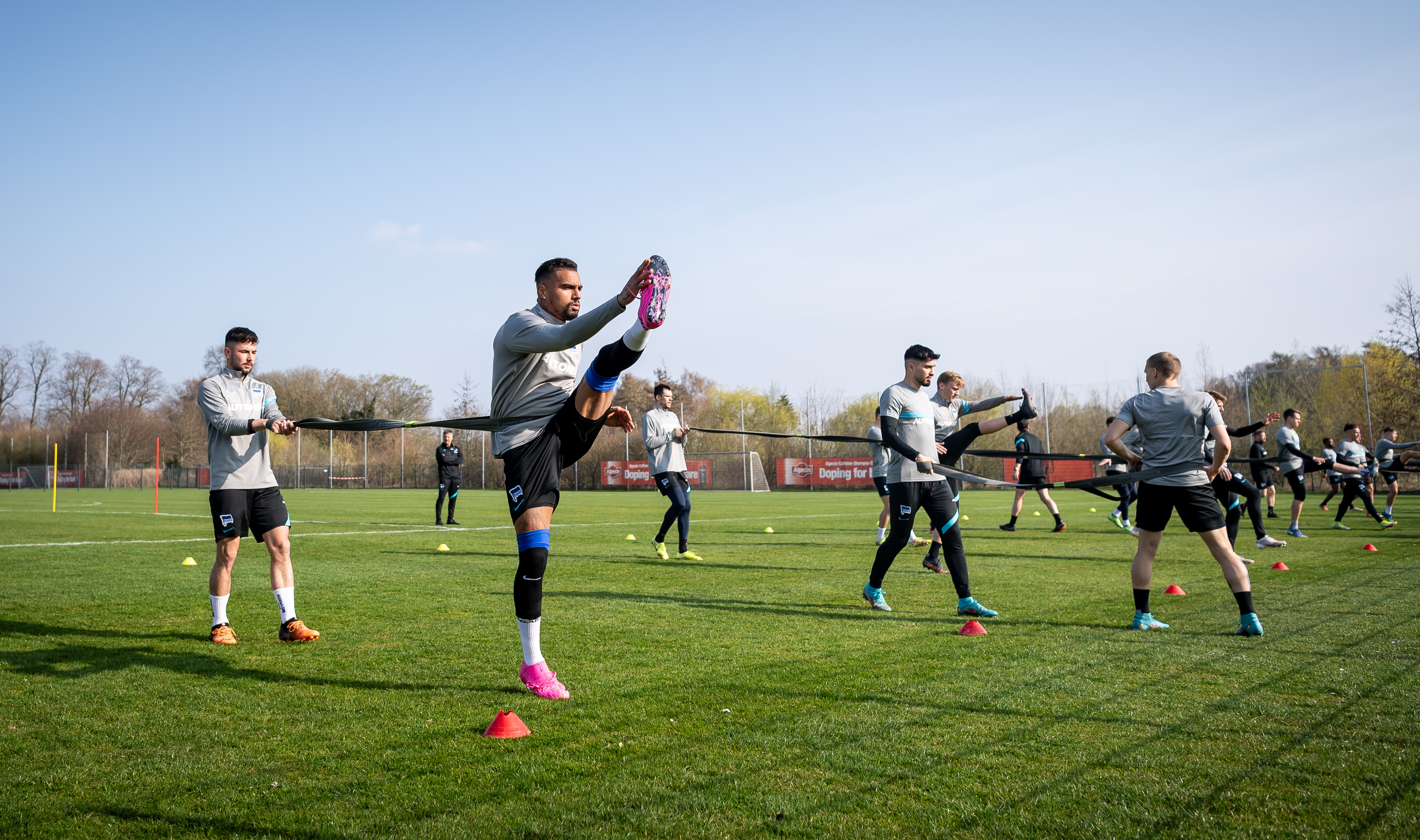 Prince Boateng und das Team von Hertha BSC führen Kraftübungen aus.