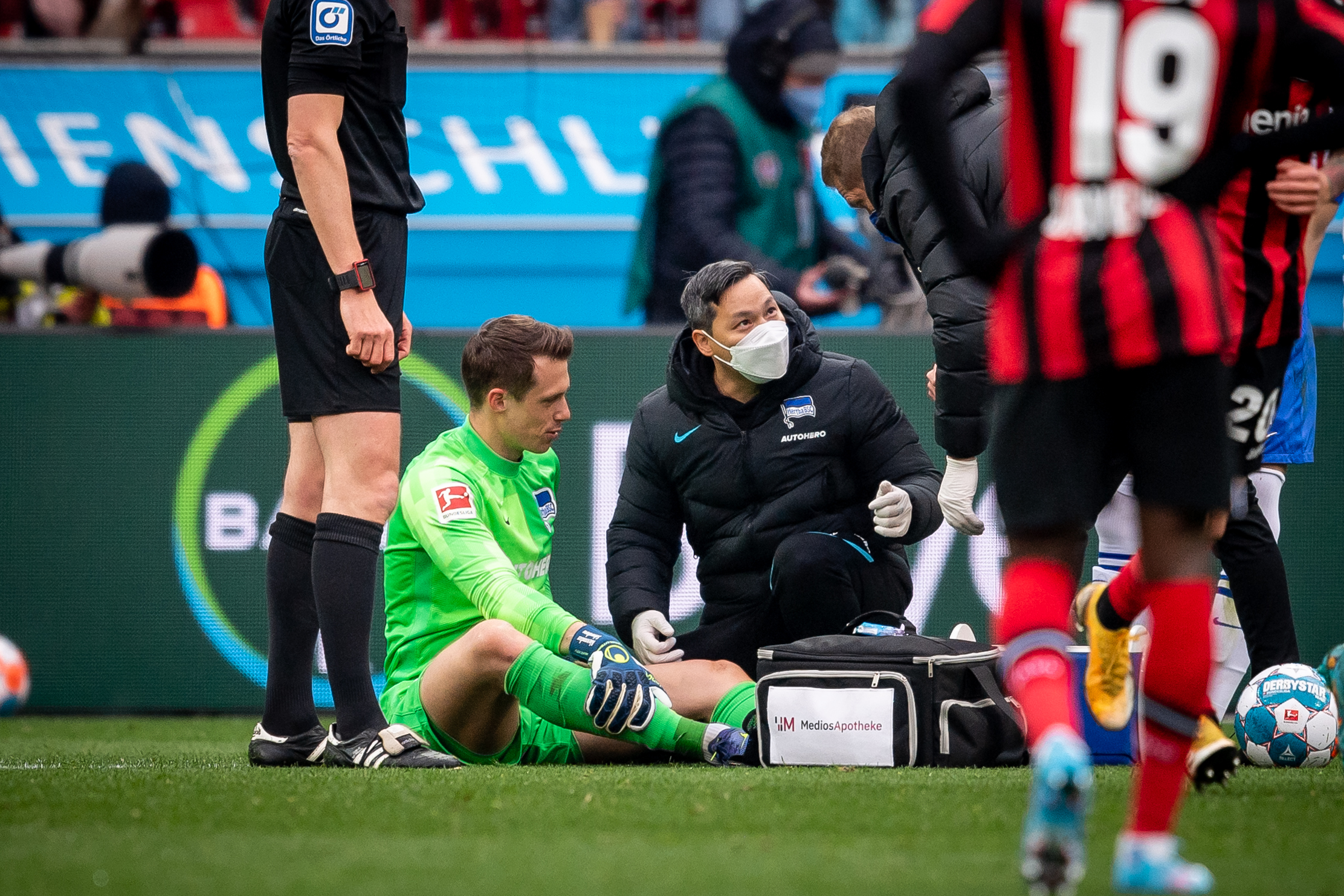 Alexander Schwolow sitzt in Leverkusen verletzt auf dem Rasen.