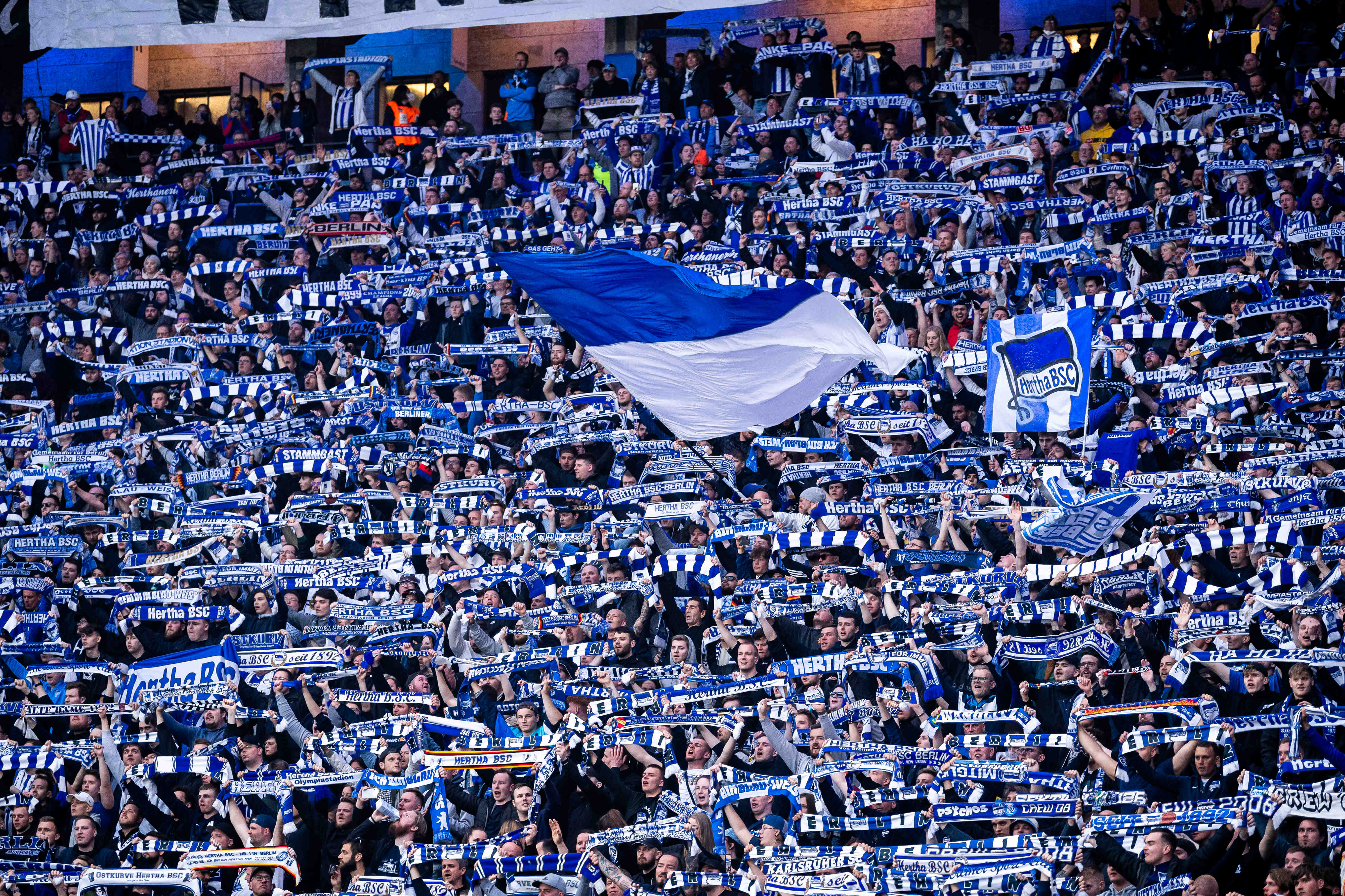 Fans mit Schals und Fahnen im Olympiastadion.