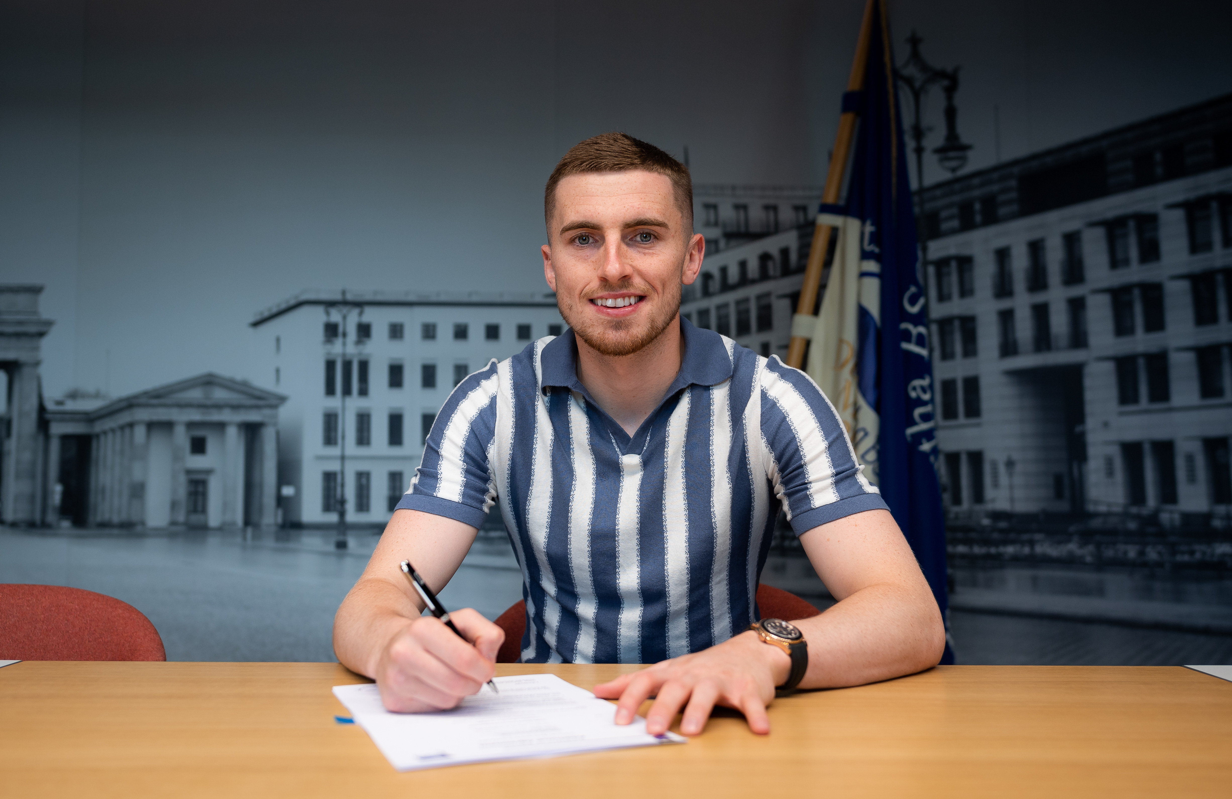 Jonjoe Kenny signs his contract.