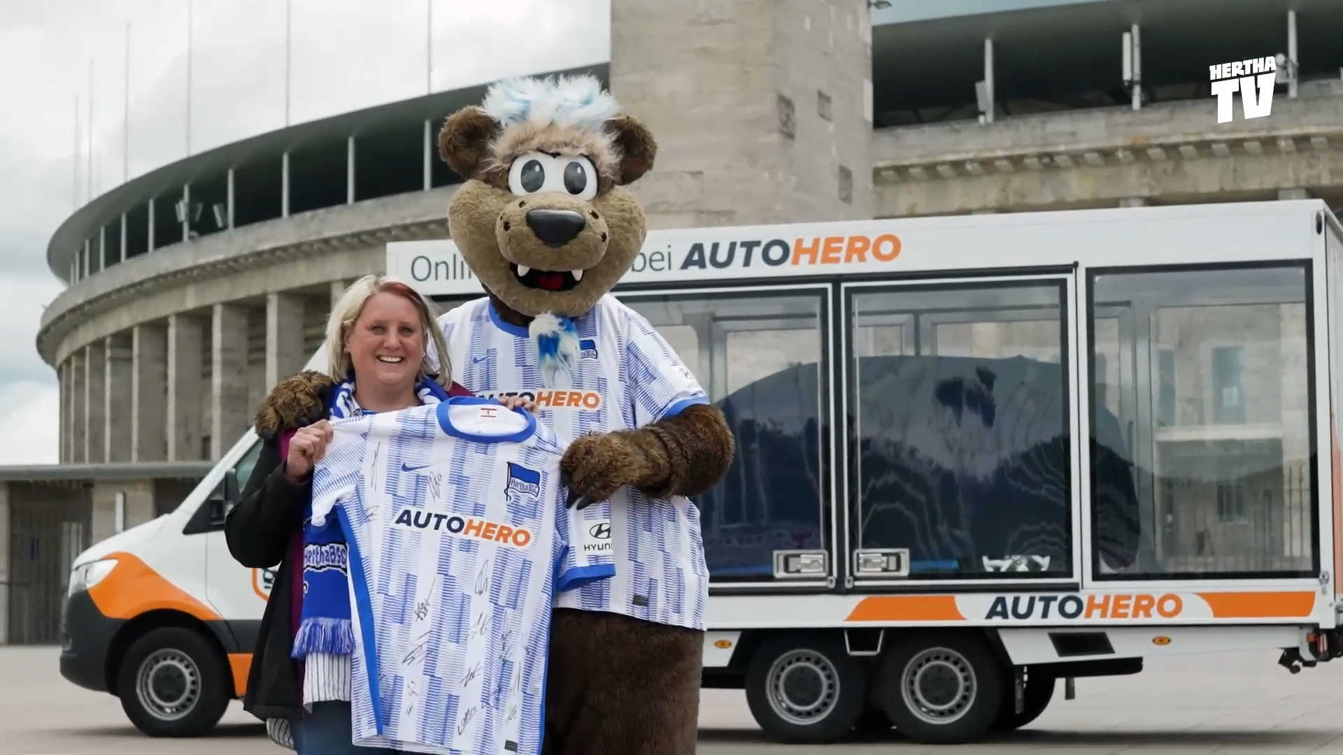 Herthinho posiert vor dem Olympiastadion mit der Gewinnerin des Autohero-Gewinnspiels.
