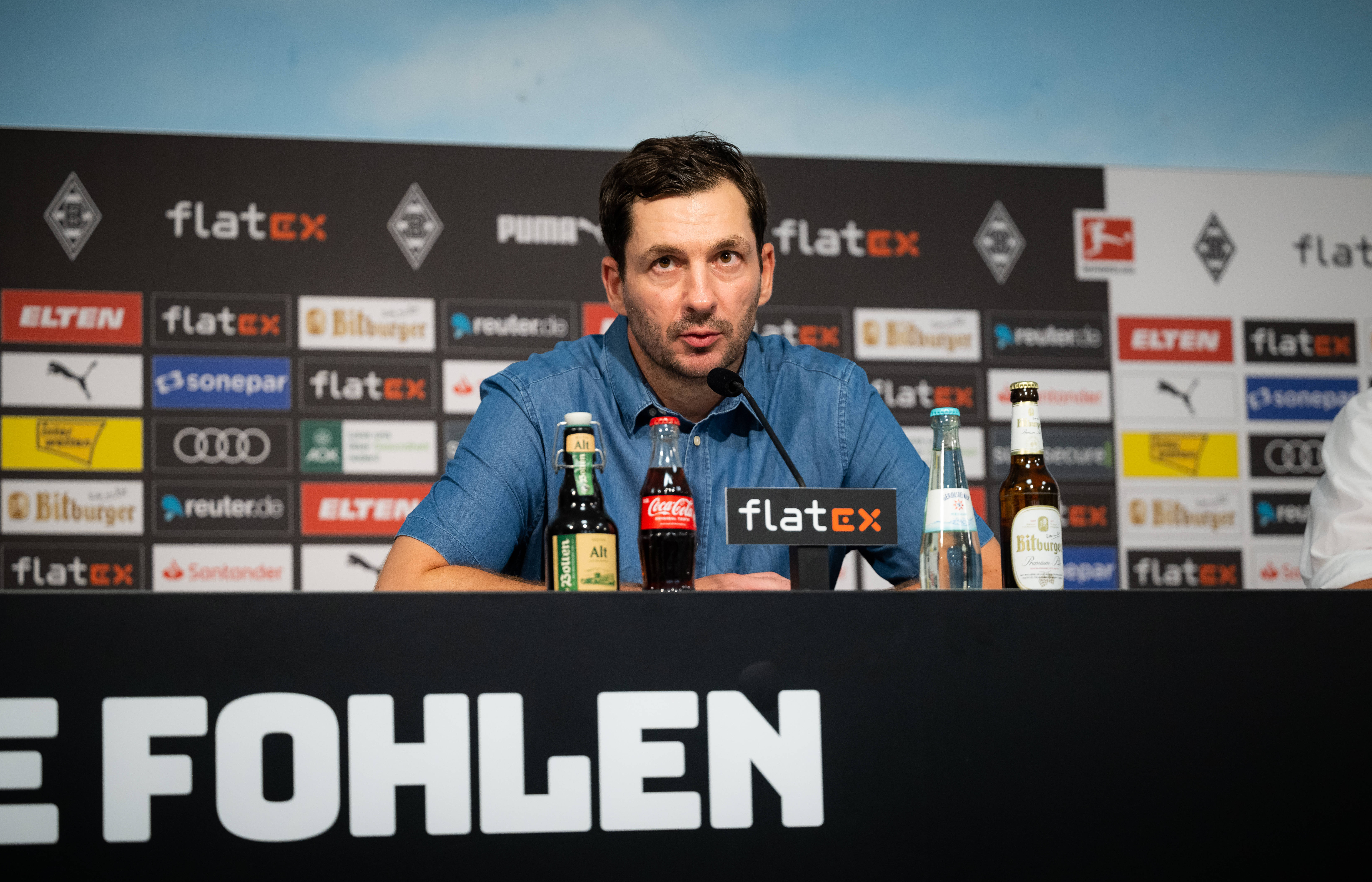 Sandro Schwarz auf dem Podium bei einer Pressekonferenz.