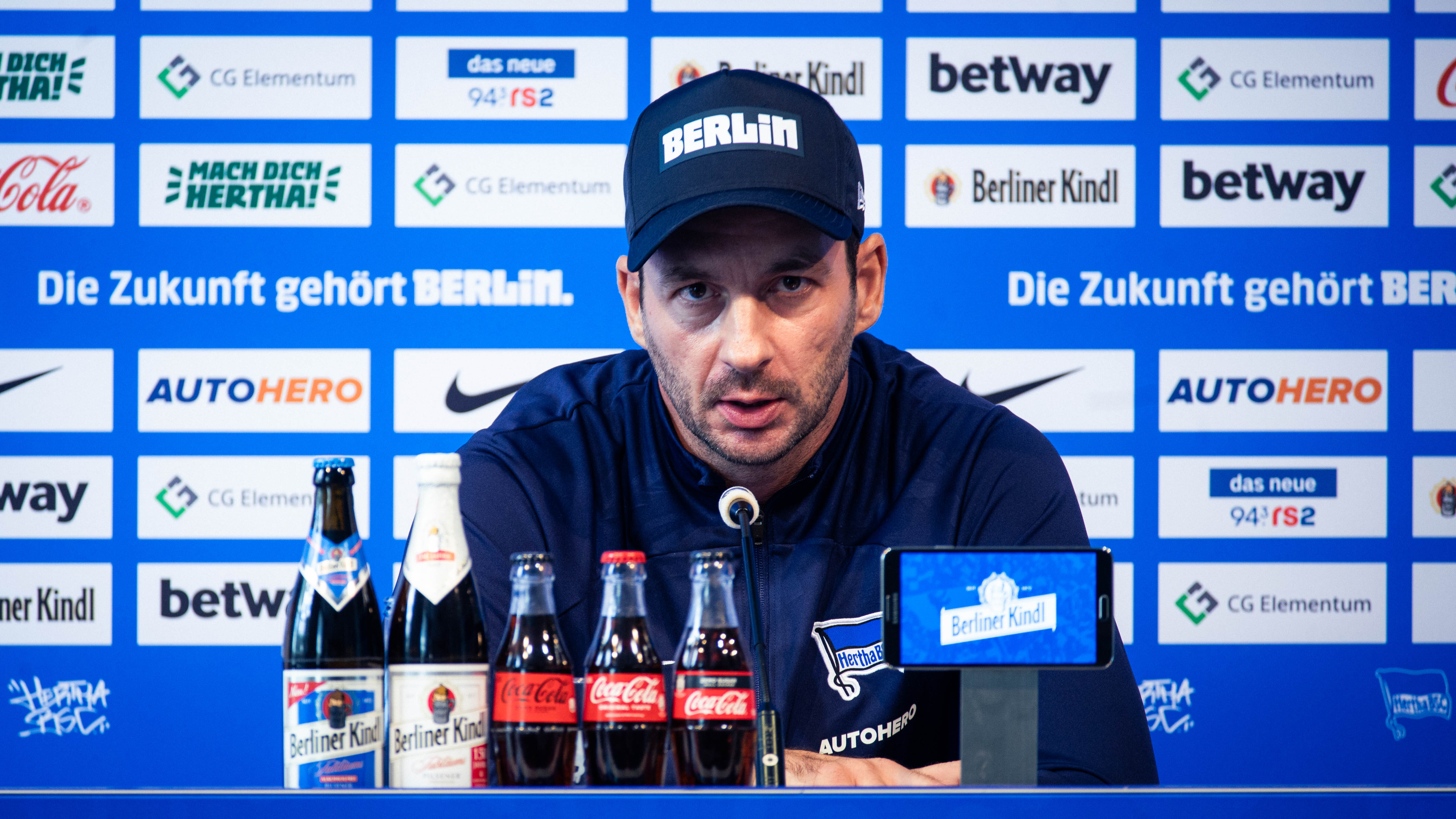 Sandro Schwarz vor dem Mikrofon bei einer Pressekonferenz.