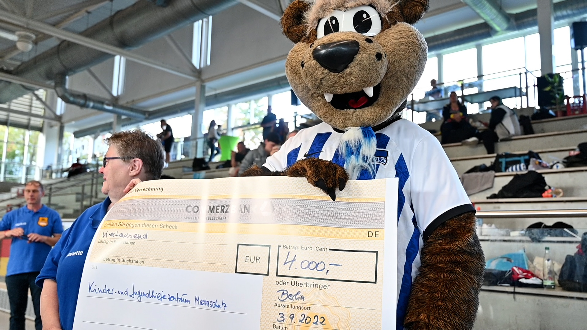 Herthinho überreicht den Scheck beim Benefizturnier der Hertha Cops.