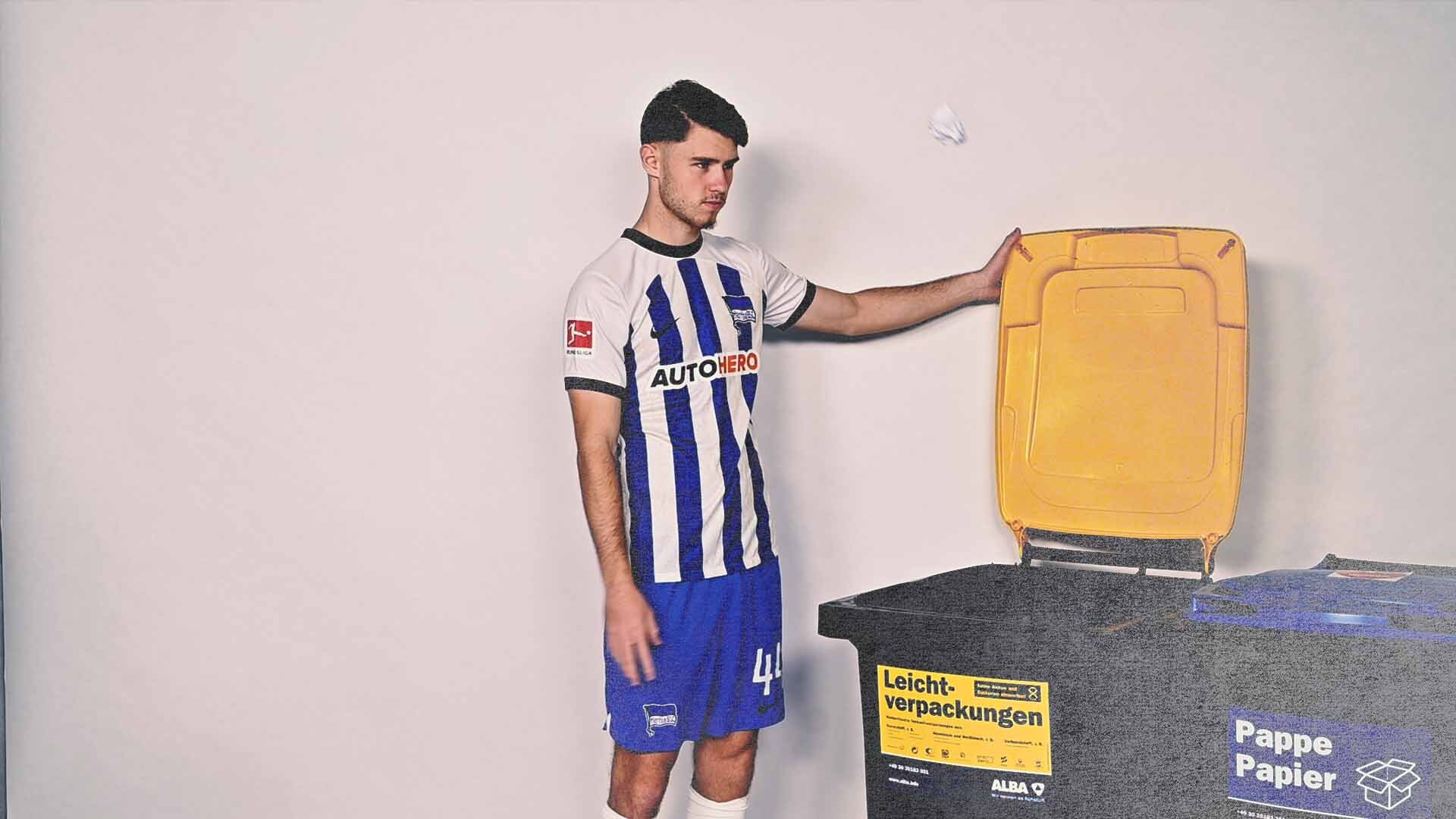 Linus Gechter steht an einer offenen Mülltonne.