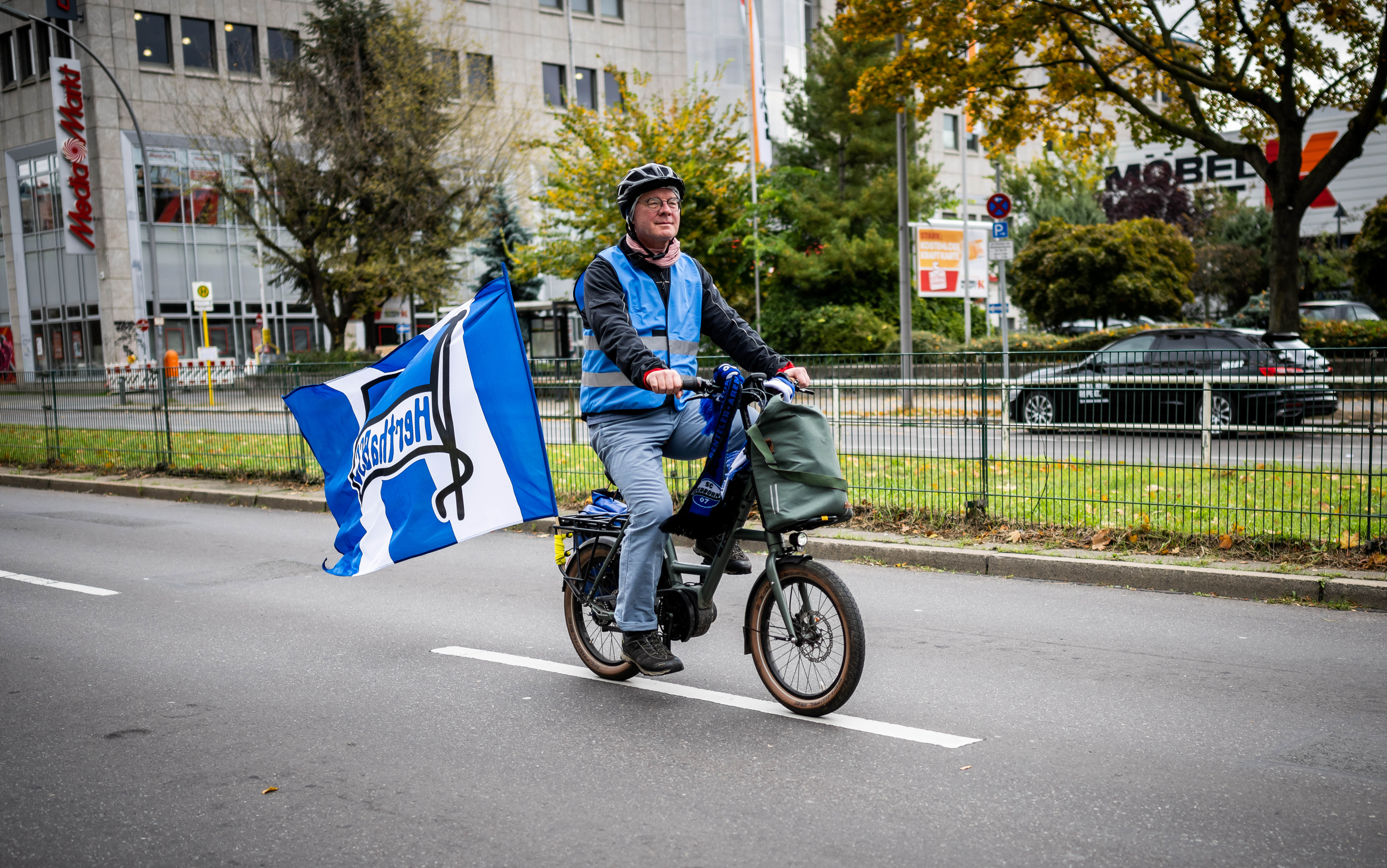 Ein Teilnehmer der Fahrradtour ist mit großer Hertha-Fahne unterwegs.