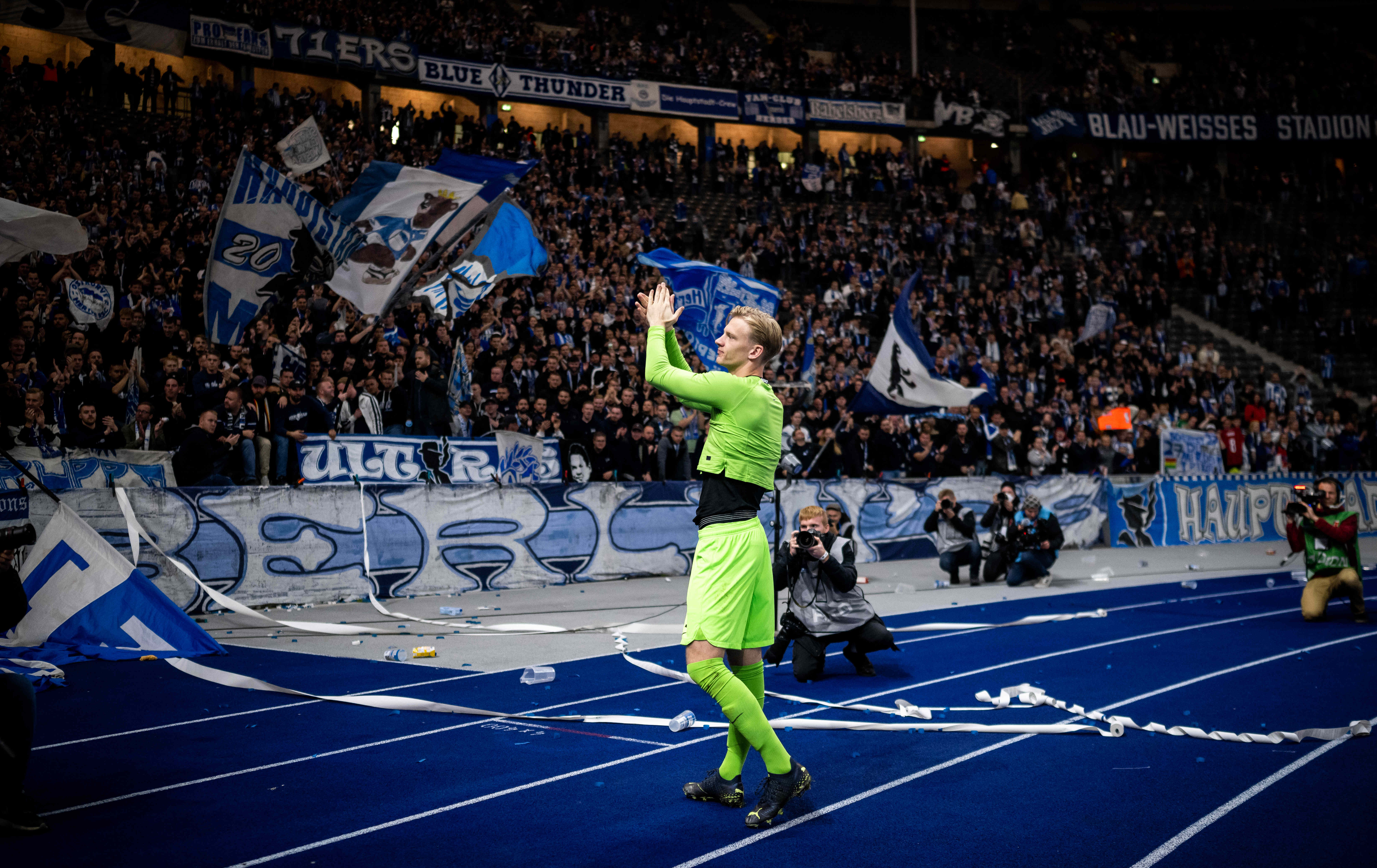 Oliver Christensen steht vor der Ostkurve und bekommt Applaus von den Fans.