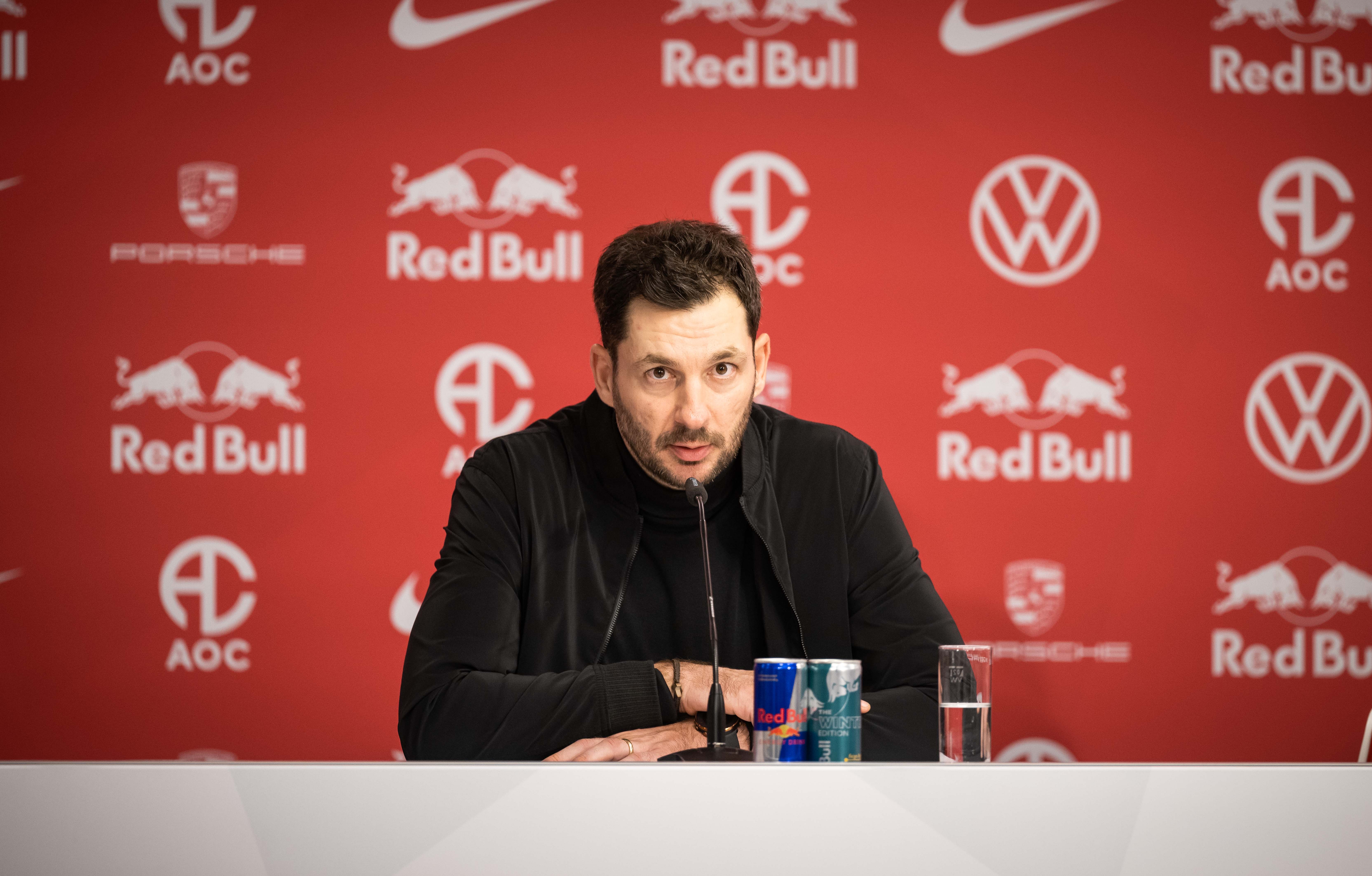 Sandro Schwarz sitzt auf dem Podium im Leipziger Stadion.