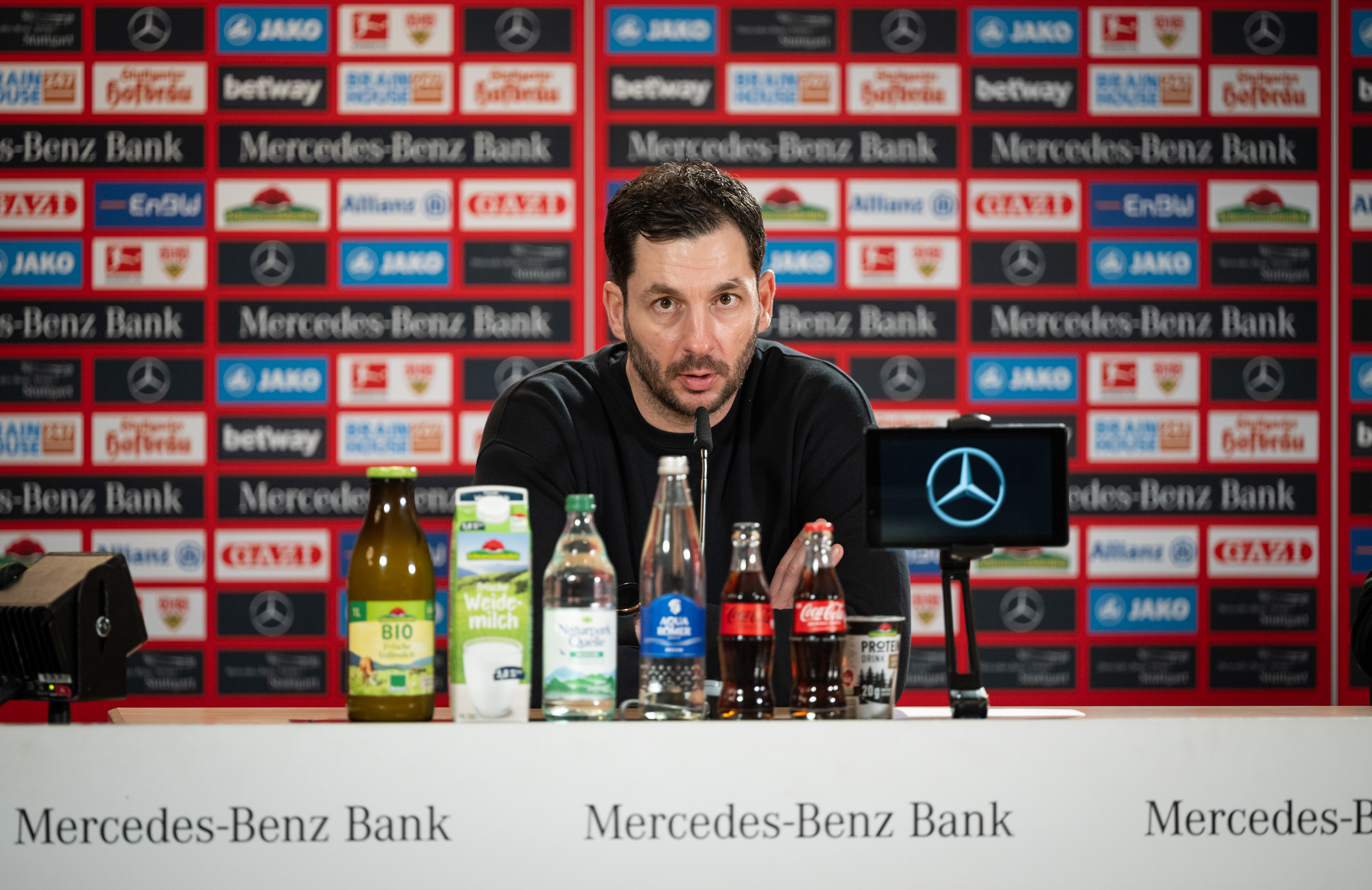 Sandro Schwarz sitzt auf dem Podium in der Stuttgarter Arena.