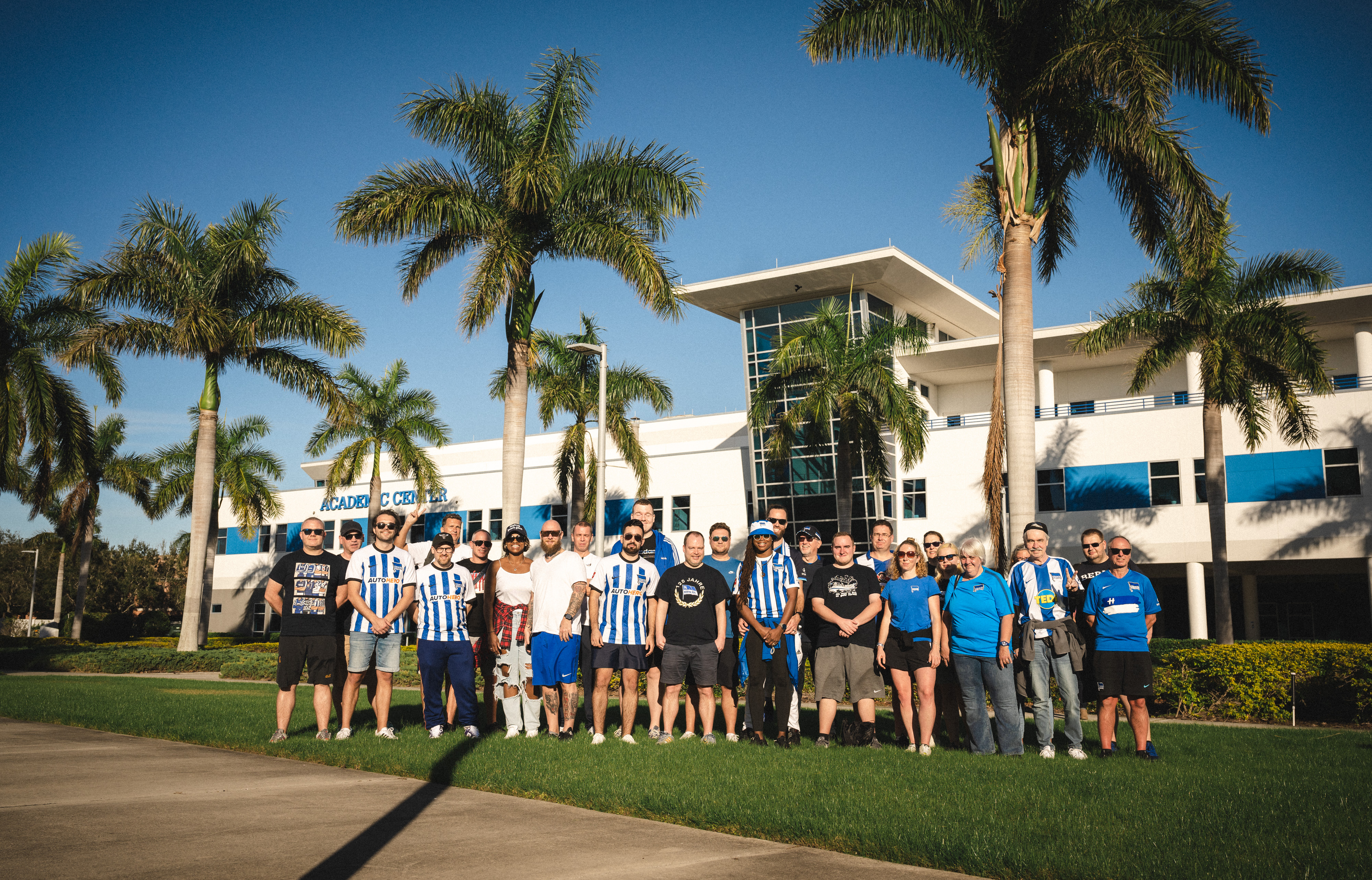Unsere Fans posieren vor Palmen auf der IMG Academy.