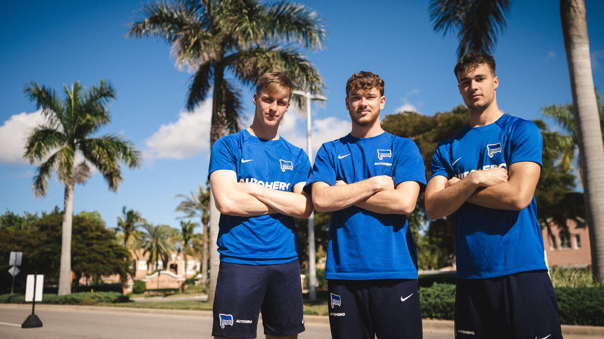 Tim Goller, Pascal Klemens und Leon Cuk posieren vor Palmen auf dem Gelände der IMG Academy.