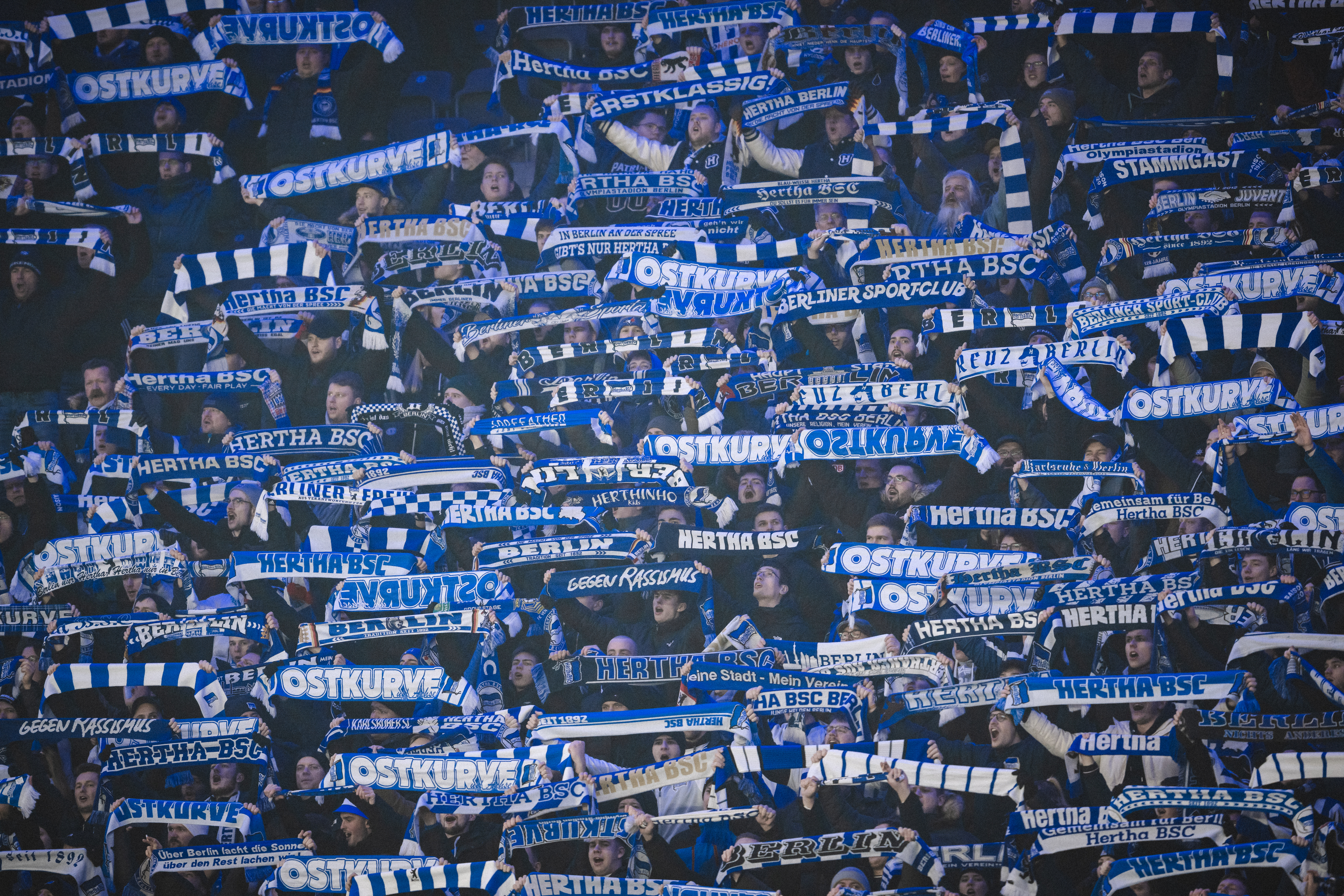 Hertha-Fans mit Schals über den Köpfen