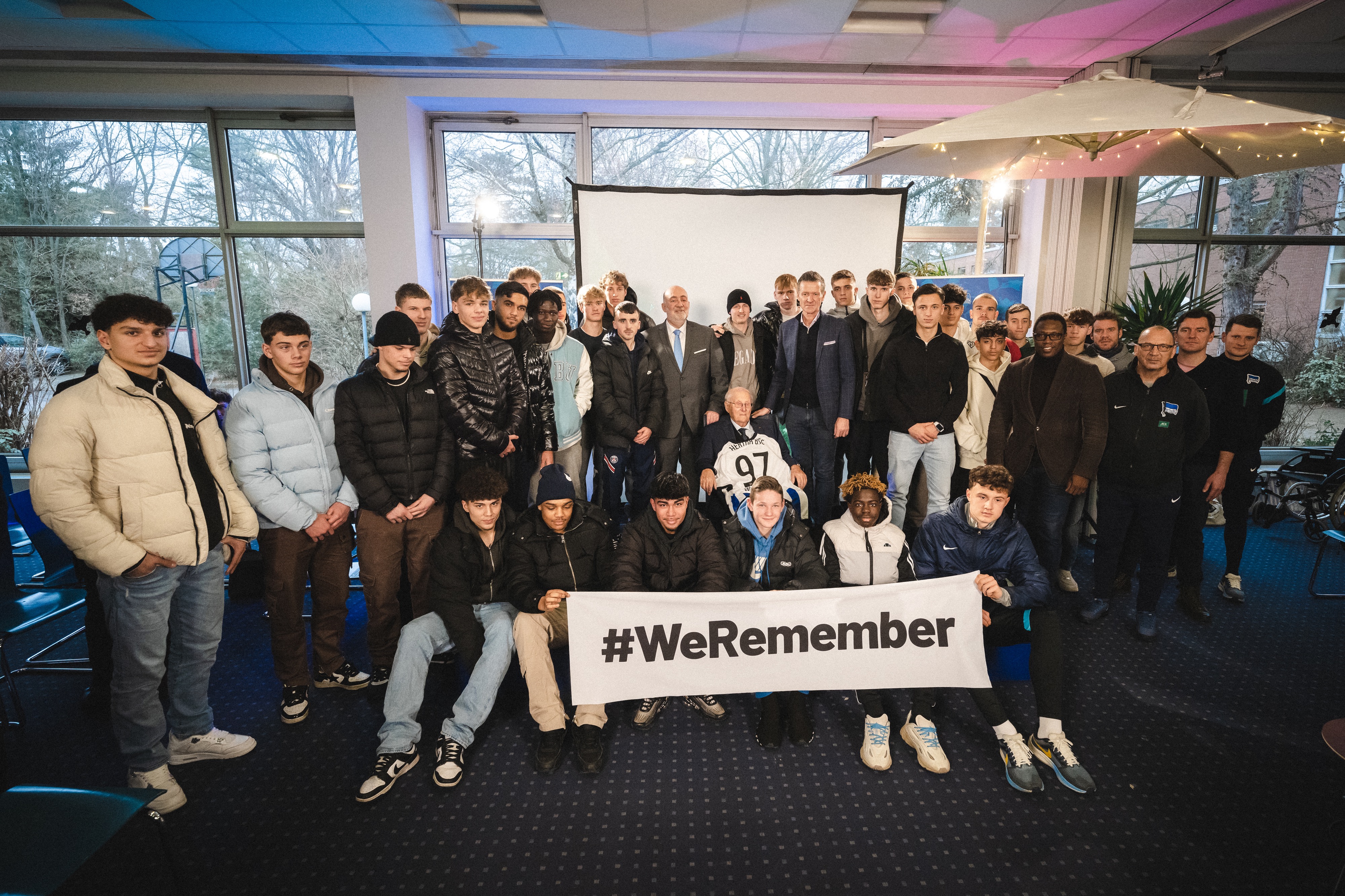 Thomas E. Herrich und zahlreiche Herthaner halten mit Albrecht Weinberg und Ron Prosor das Banner #WeRemember hoch.