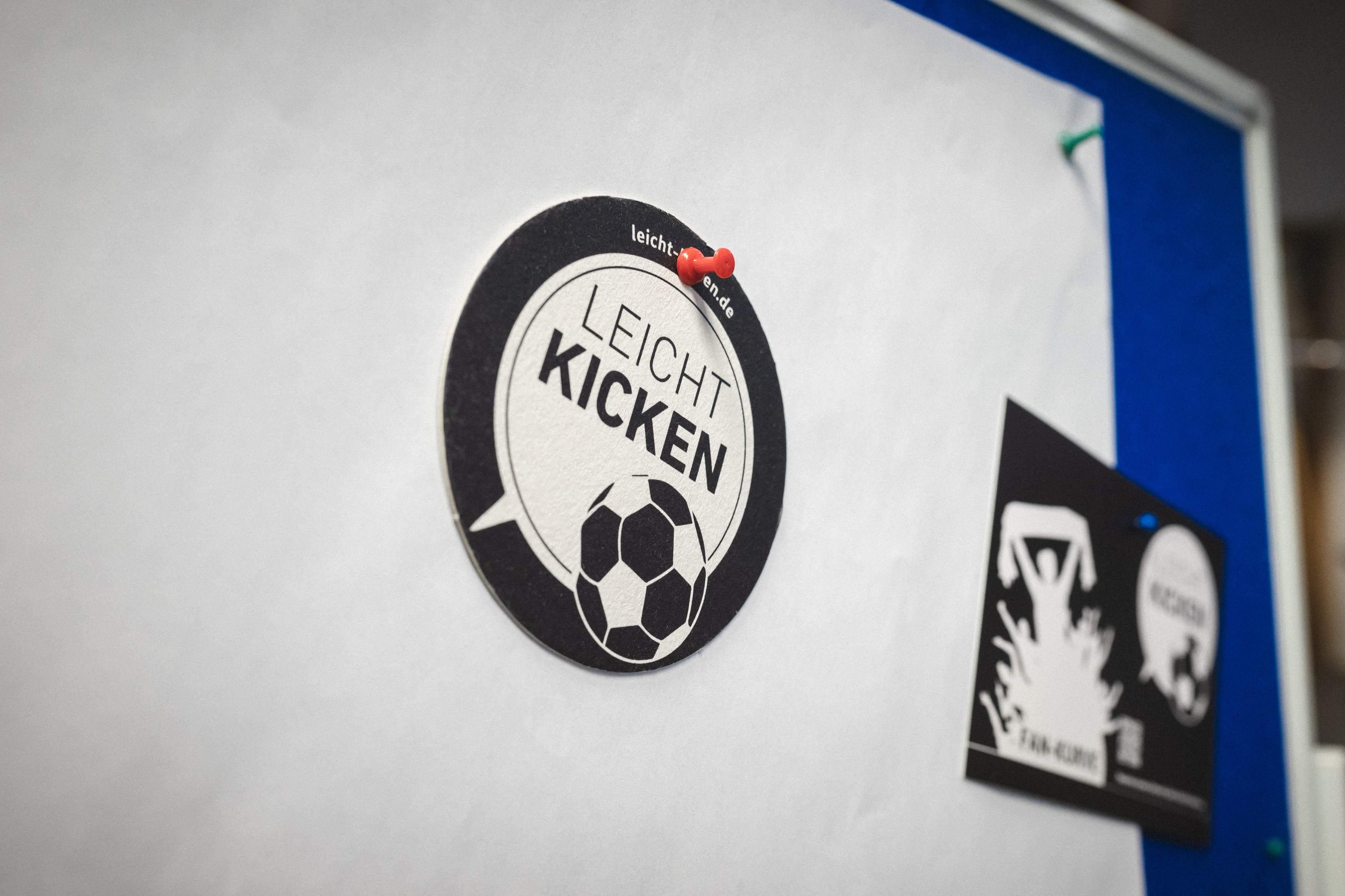 Das Logo von "Leicht Kicken" an einer Wand gepinnt.