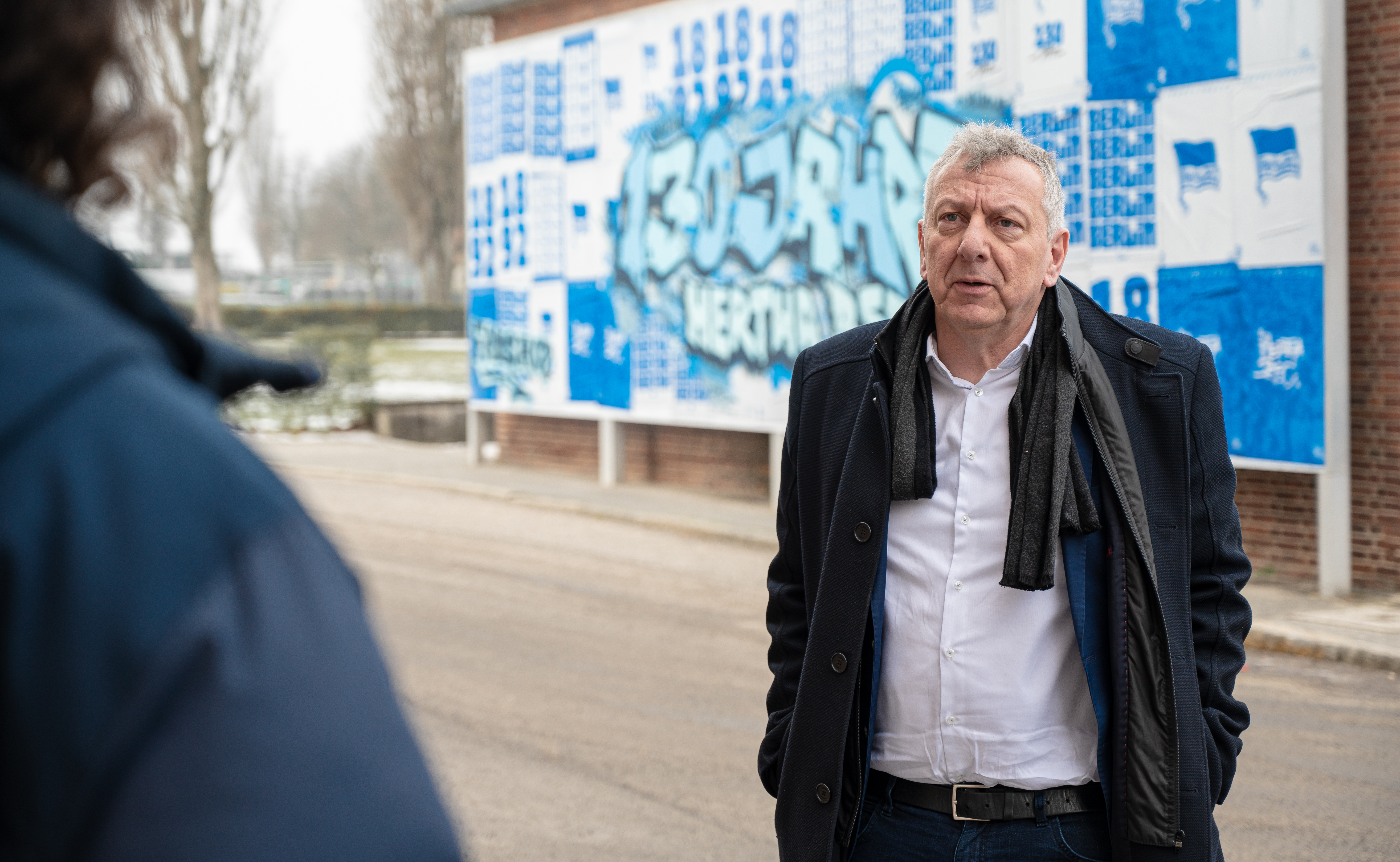 Prof. Thomas Sakschewski steht vor dem blau-weißen Welcomeboard an der Geschäftsstelle.