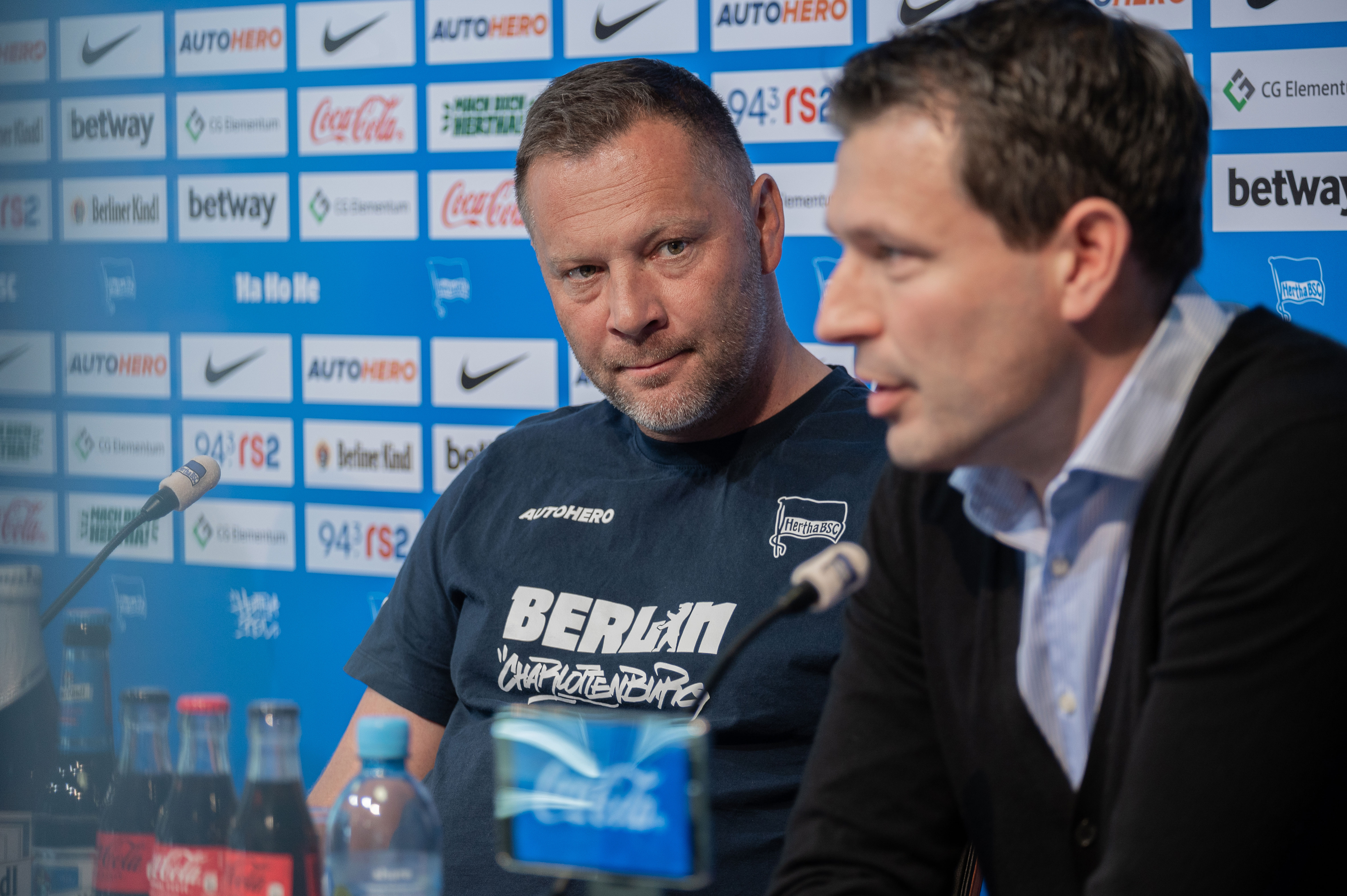 Pál Dárdai looking at Benjamin Weber as the latter speaks at the press conference.