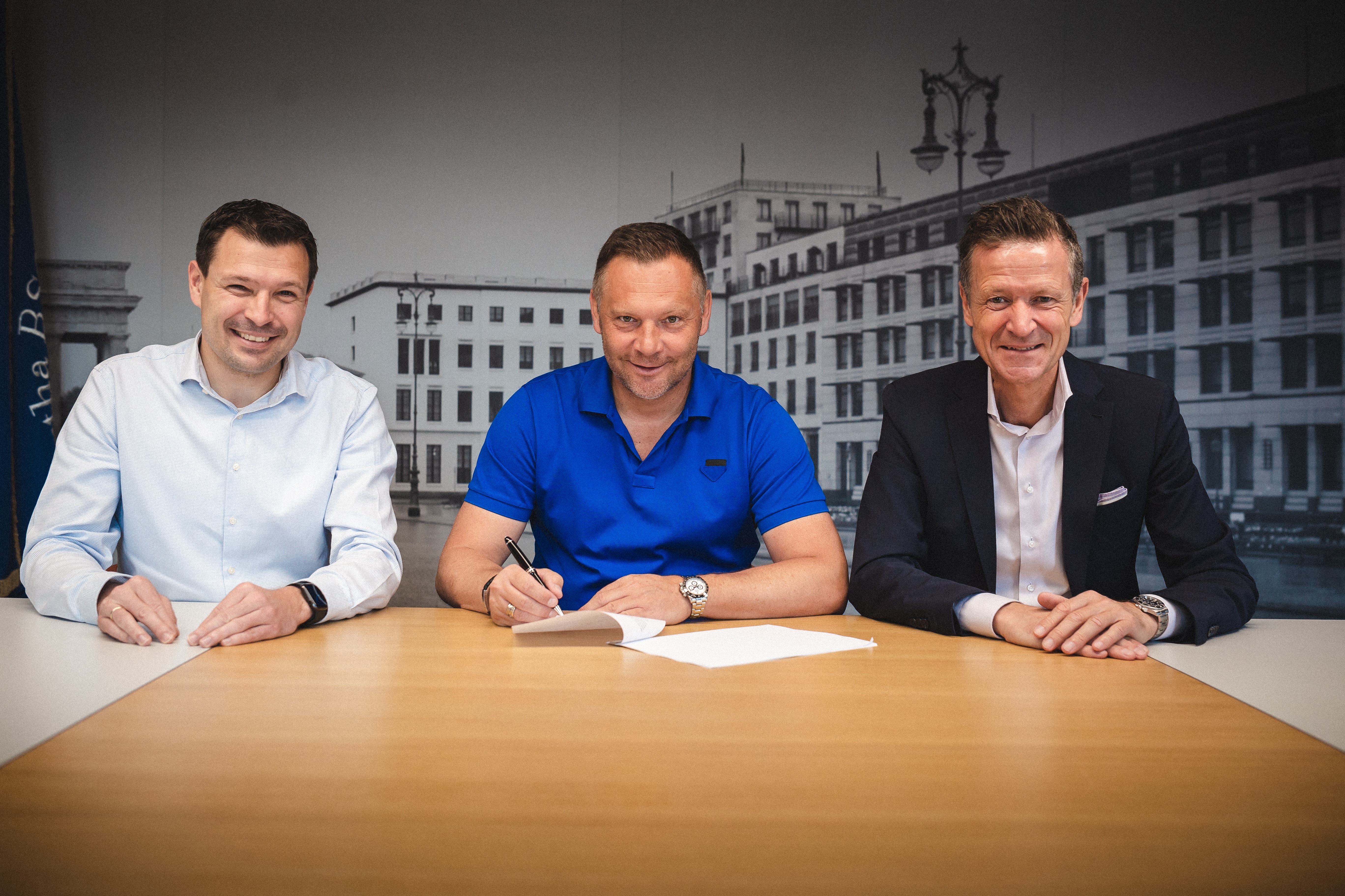 Benjamin Weber, Pál Dárdai and Thomas E. Herrich sitting at the table for the contract signing.