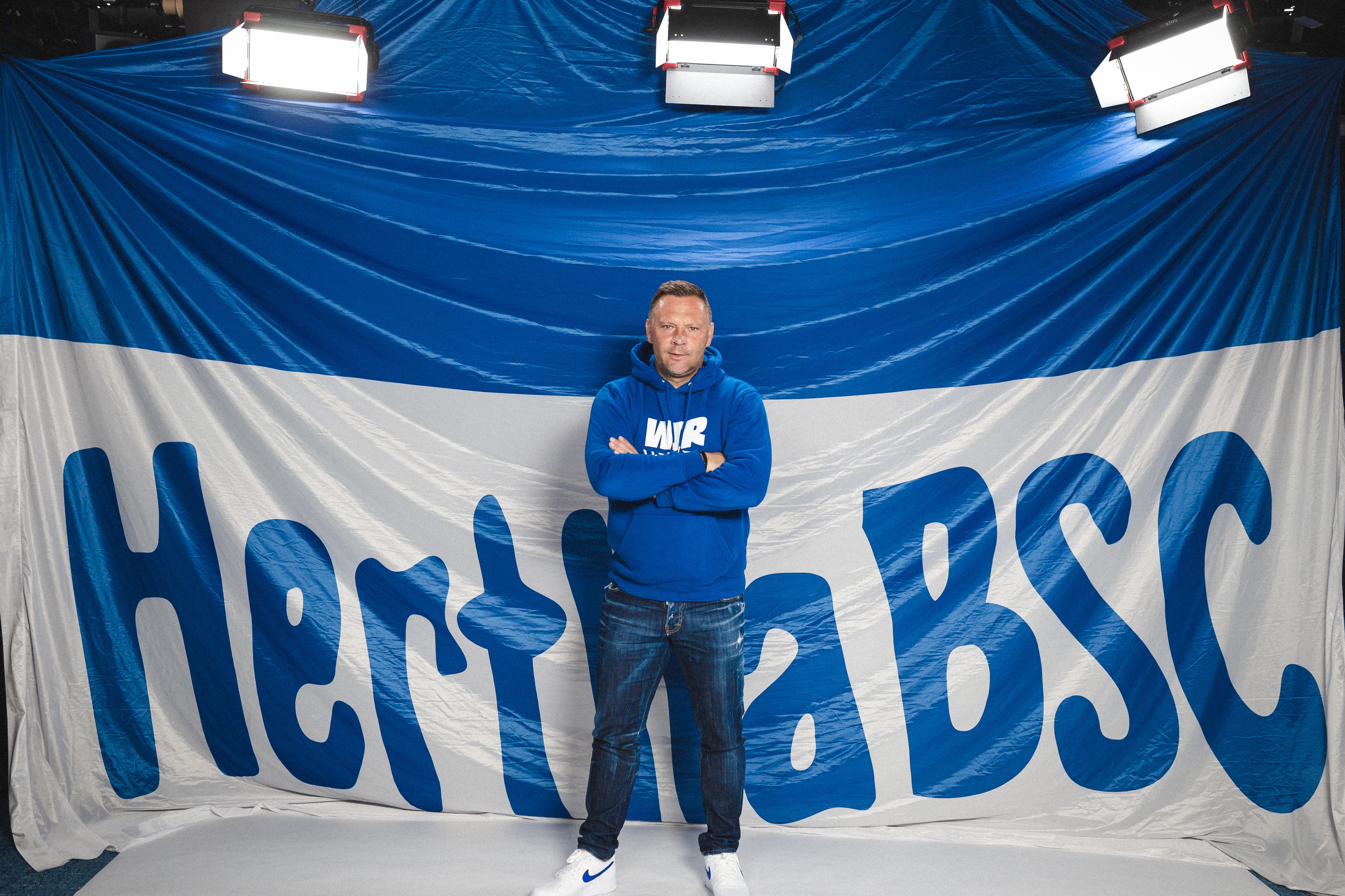 Pál Dárdai posiert vor einer großen Hertha-Fahne.
