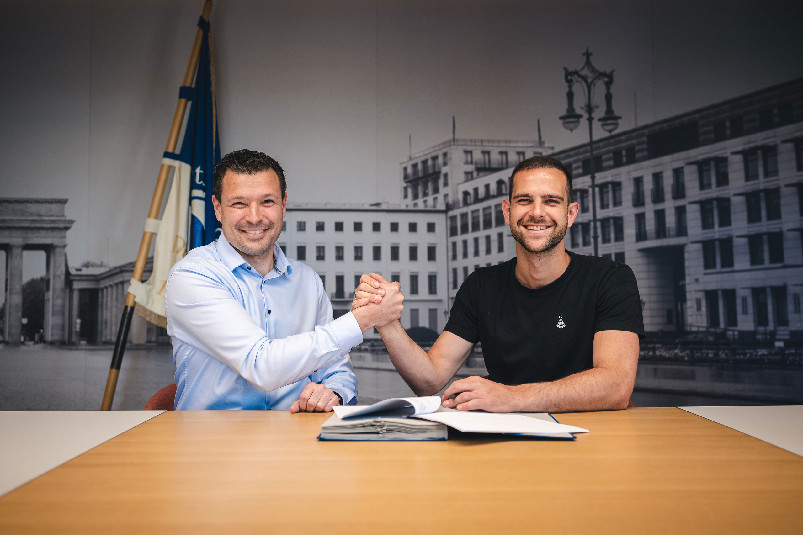 Benjamin Weber and Marius Gersbeck shake hands as the goalkeeper signs a contract with the club.