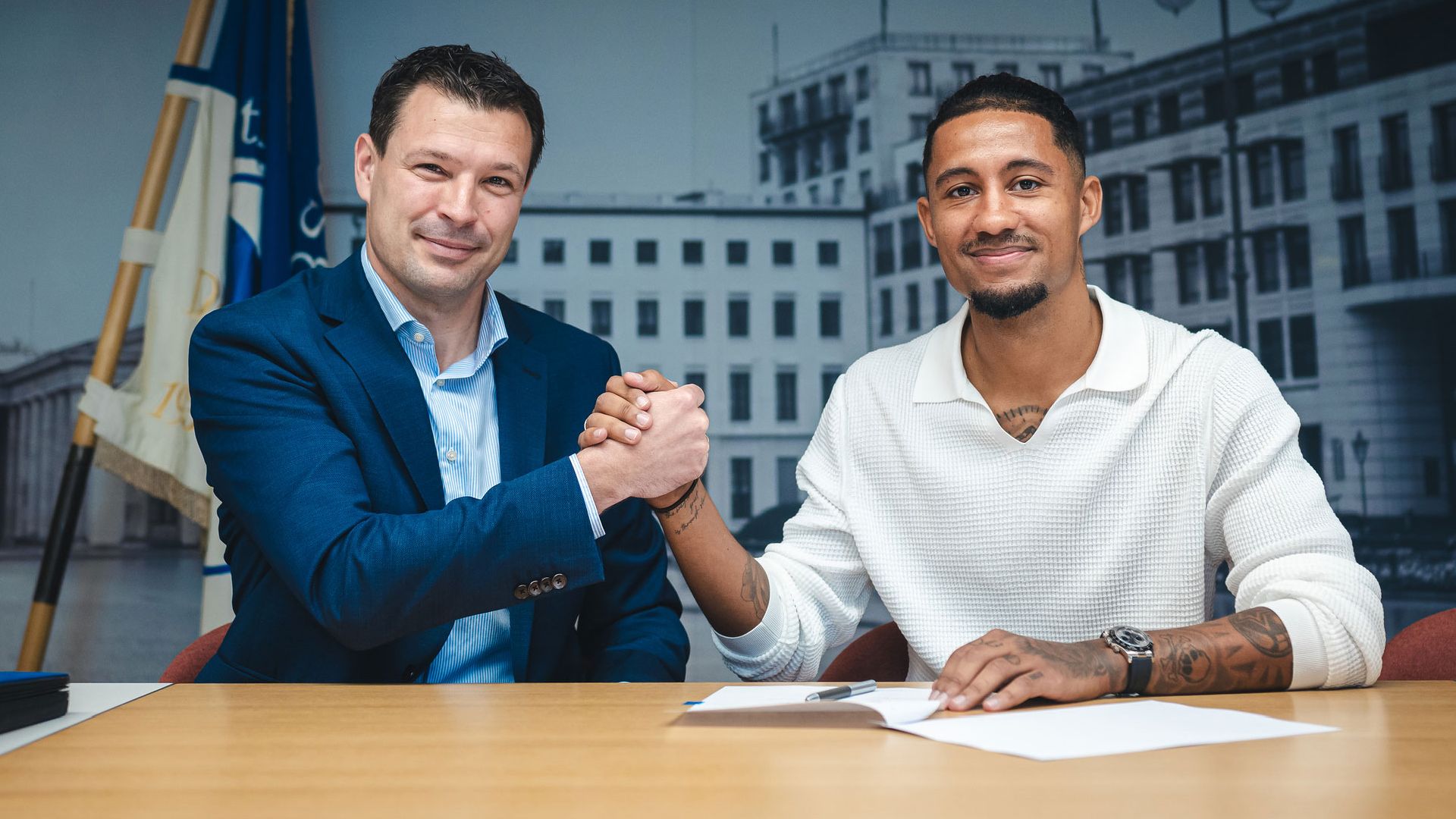 Benjamin Weber and Jeremy Dudziak shaking hands at the contract signing.