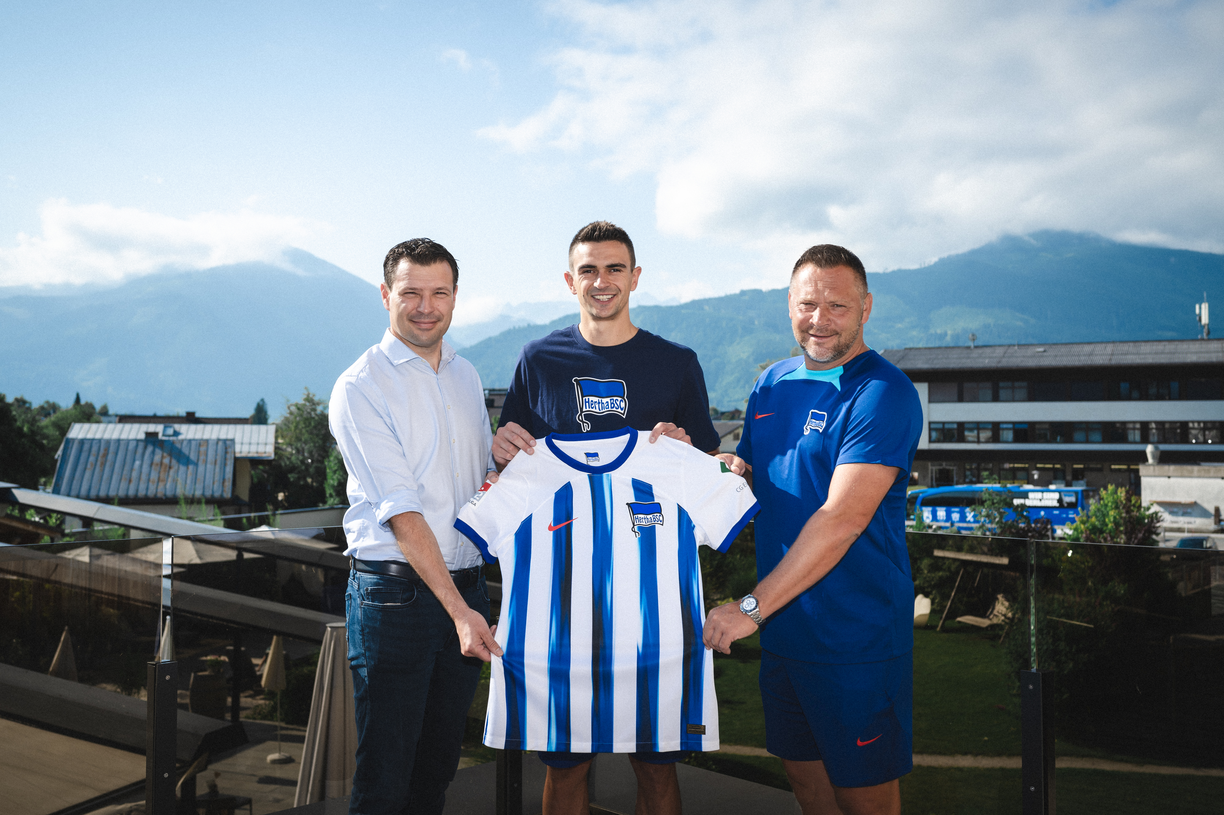 Smail Prevljak holds up the Hertha shirt together with Benjamin Weber and Pál Dárdai