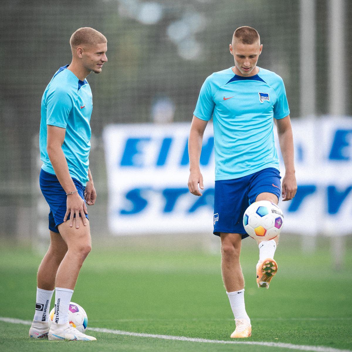 Palkó Dàrdai jongliert den Ball, Márton Dárdai schaut zu.