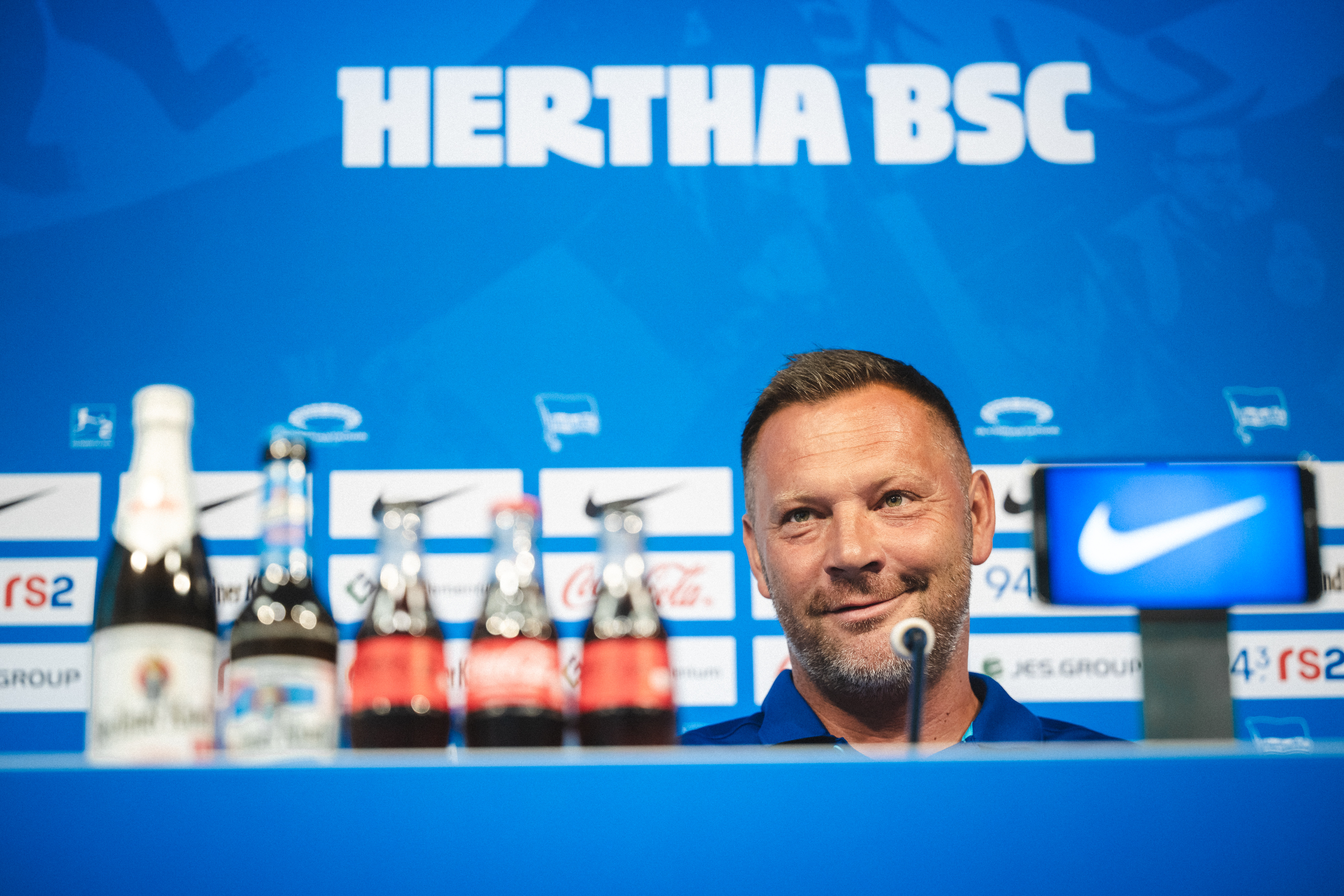 Pál Dárdai sitzt schmunzelnd bei der Pressekonferenz vor dem Auswärtsspiel in Düsseldorf.