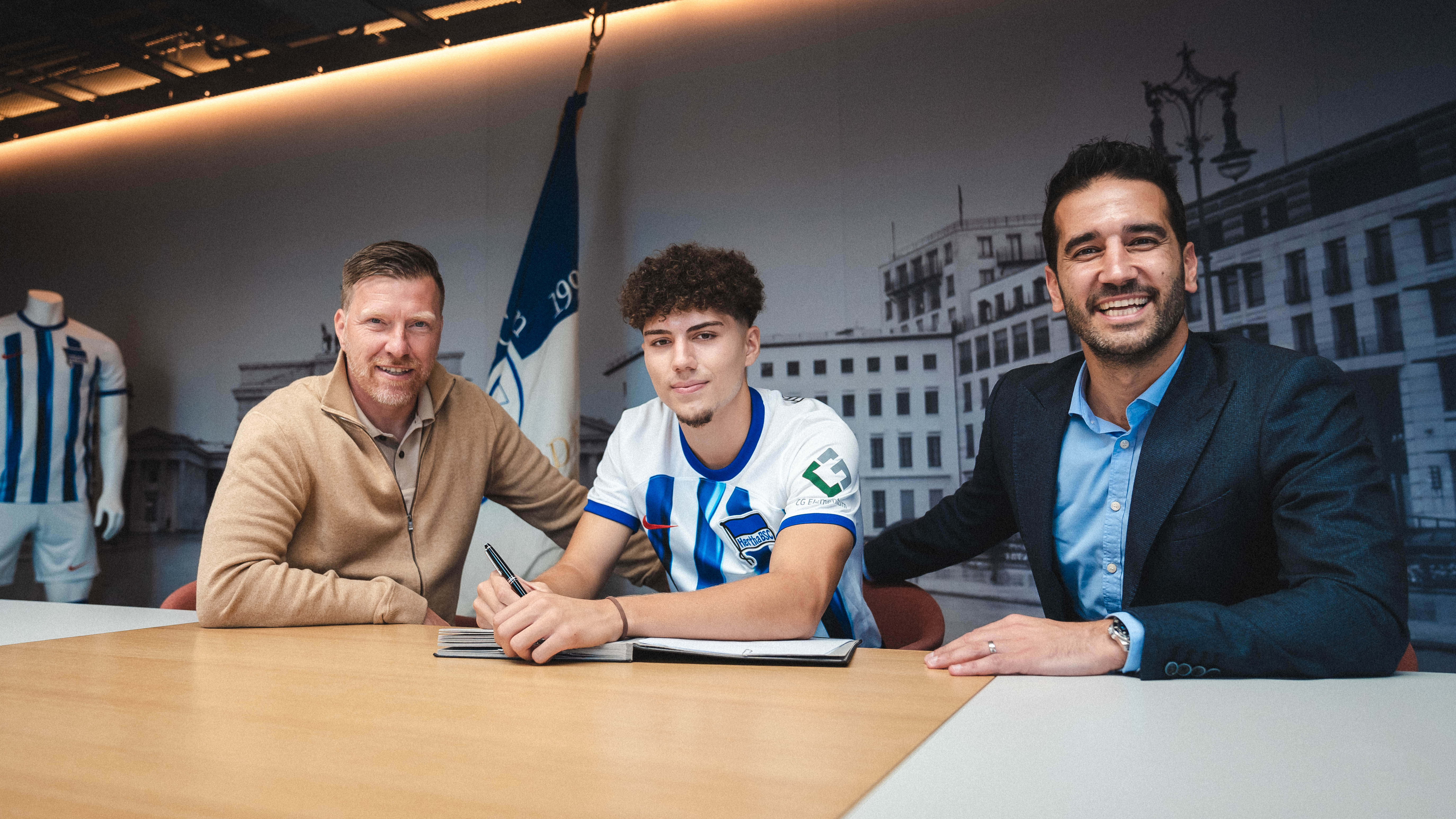 Zecke Neuendorf, Selim Telib and Sasan Gouhari smile as Telib signs his contract.