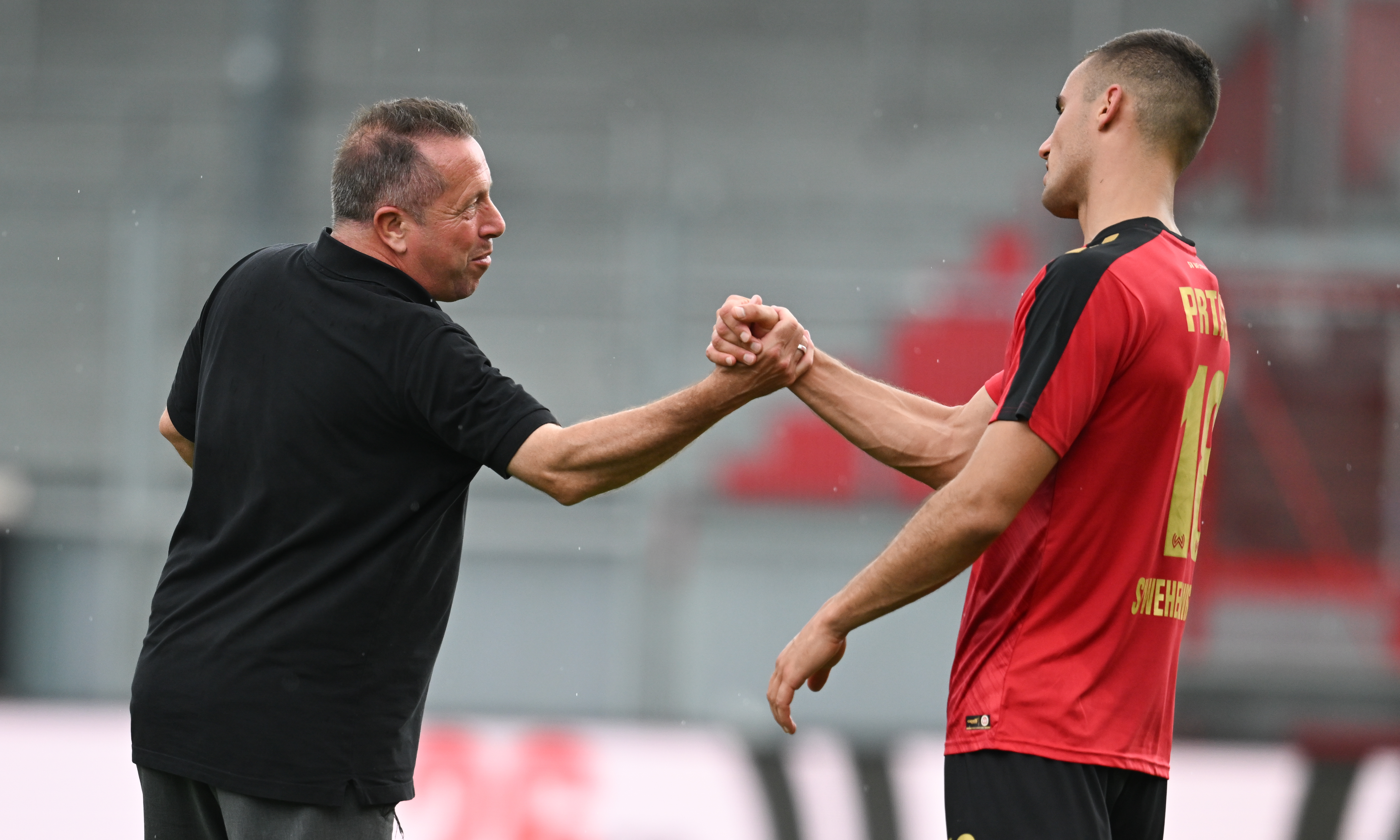 Wiesbadens Cheftrainer Markus Kauczinski (bedankt sich nach dem Spiel beim Torschützen Ivan Prtajin.