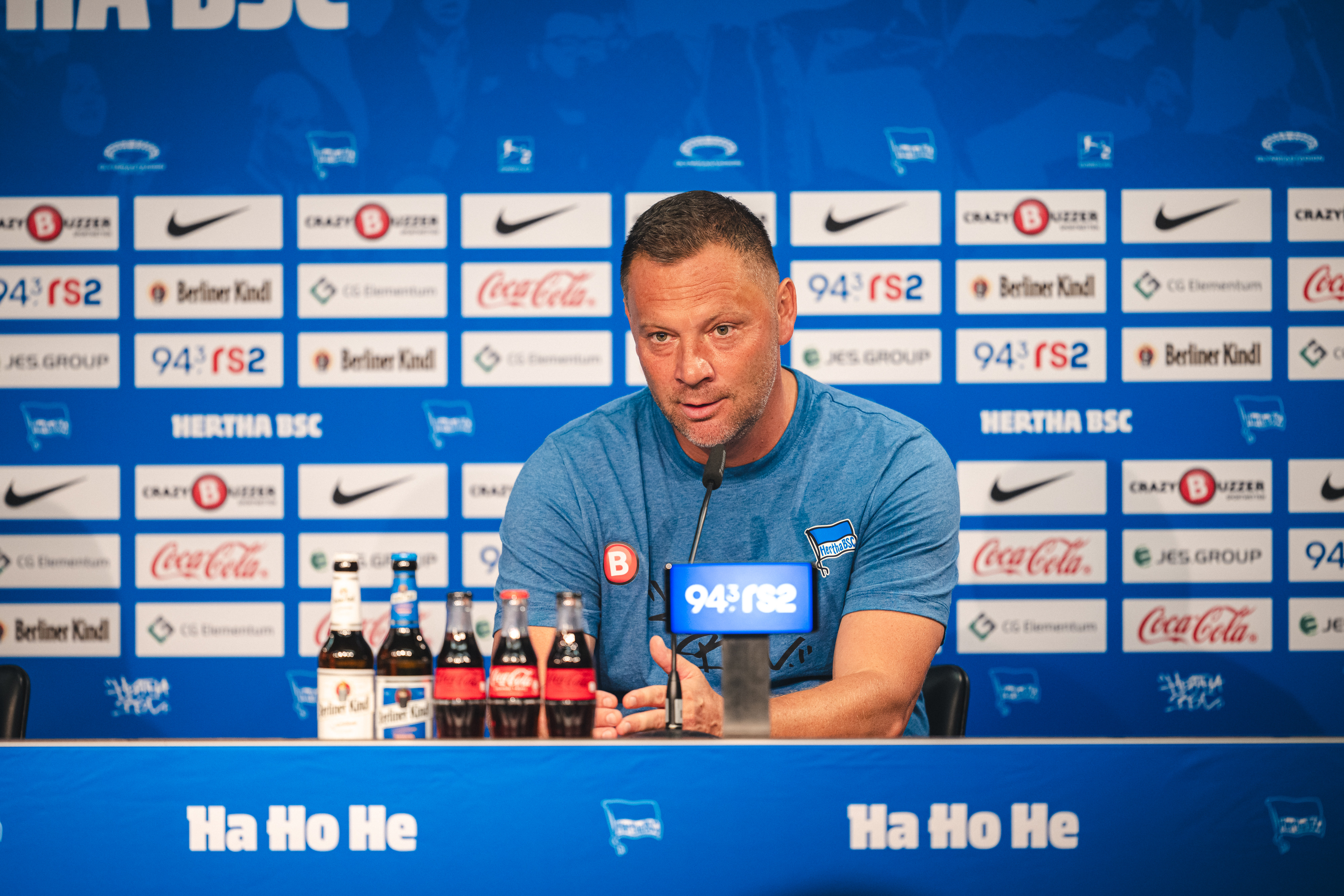 Pál Dárdai gestikuliert auf dem Podium bei der Pressekonferenz.