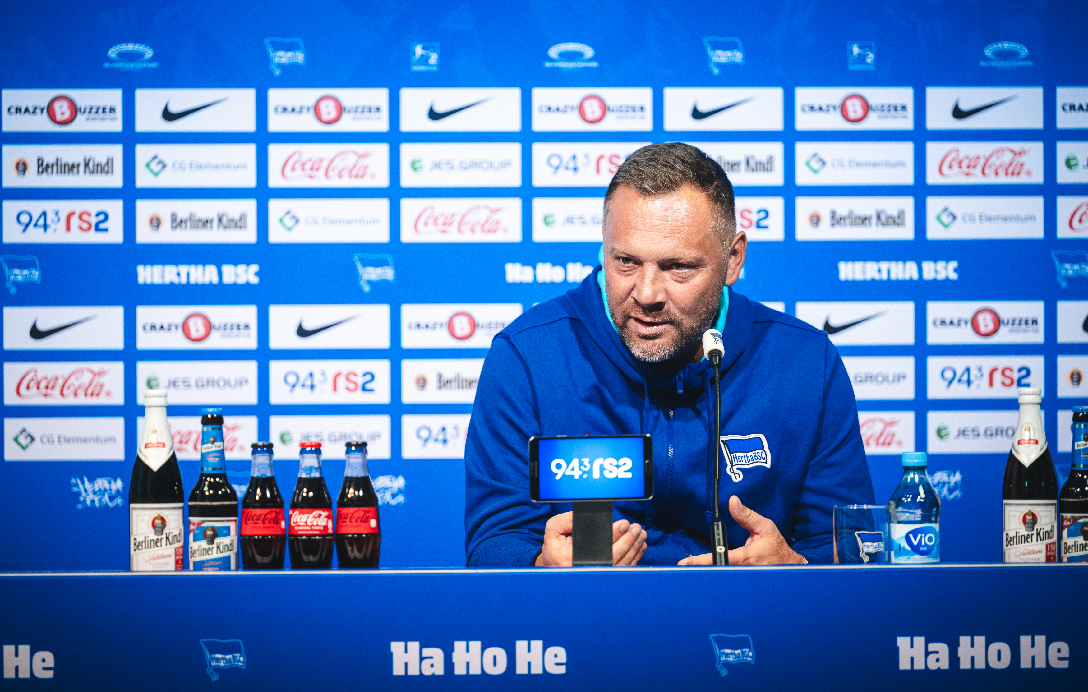 Pál Dárdai spricht bei einer Pressekonferenz auf dem Podium und gestikuliert mit seinen Händen.