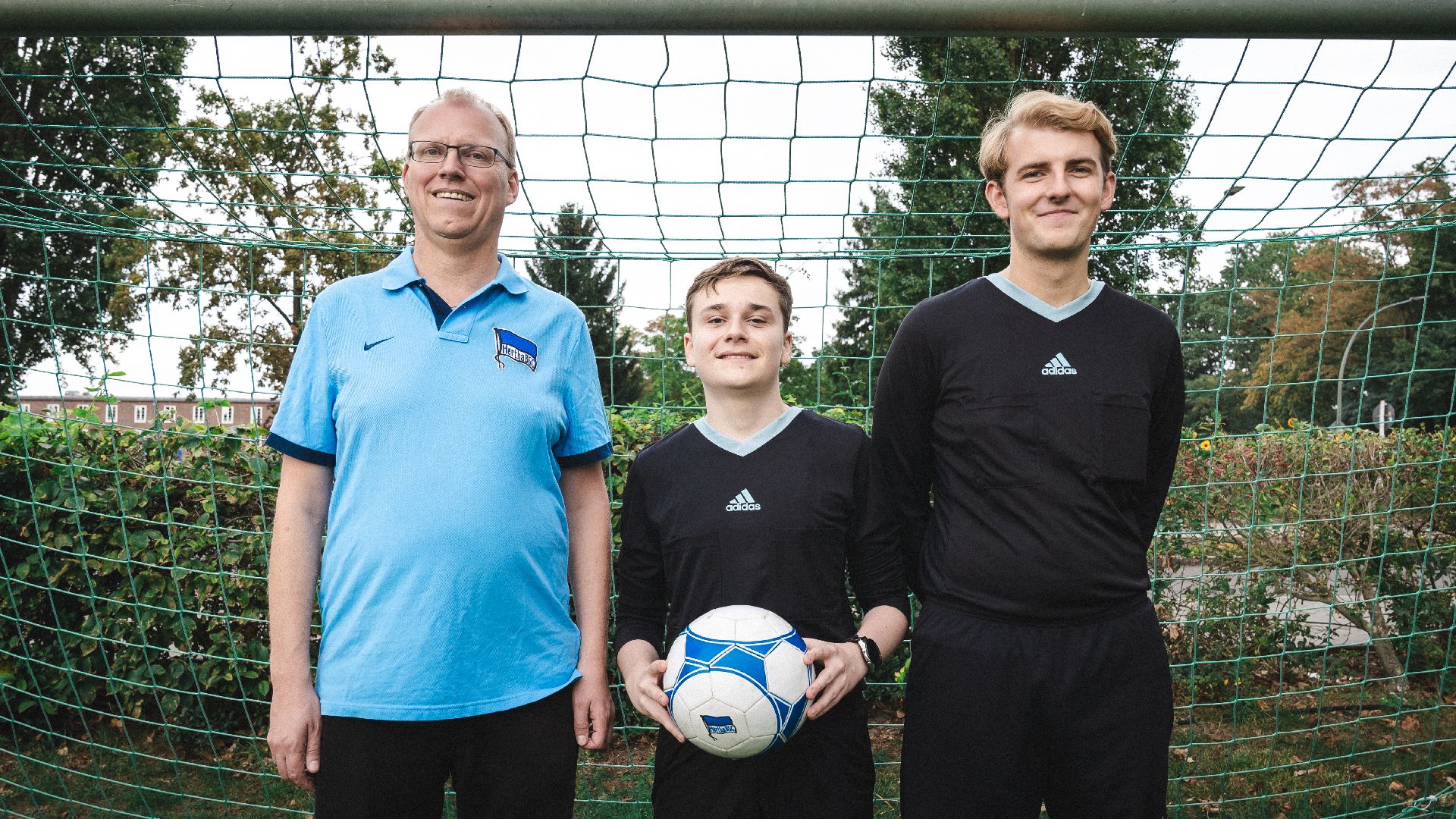 Ralf Kisting, Neil Zalkind und Vincent Pell stehen nebeneinander in einem Tor.