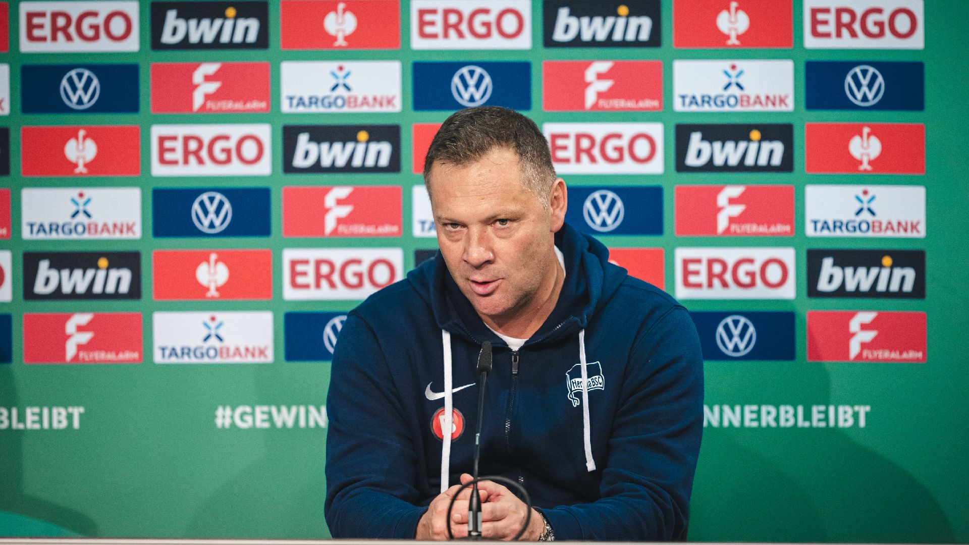 Pál Dárdai sitzt auf dem Podium.
