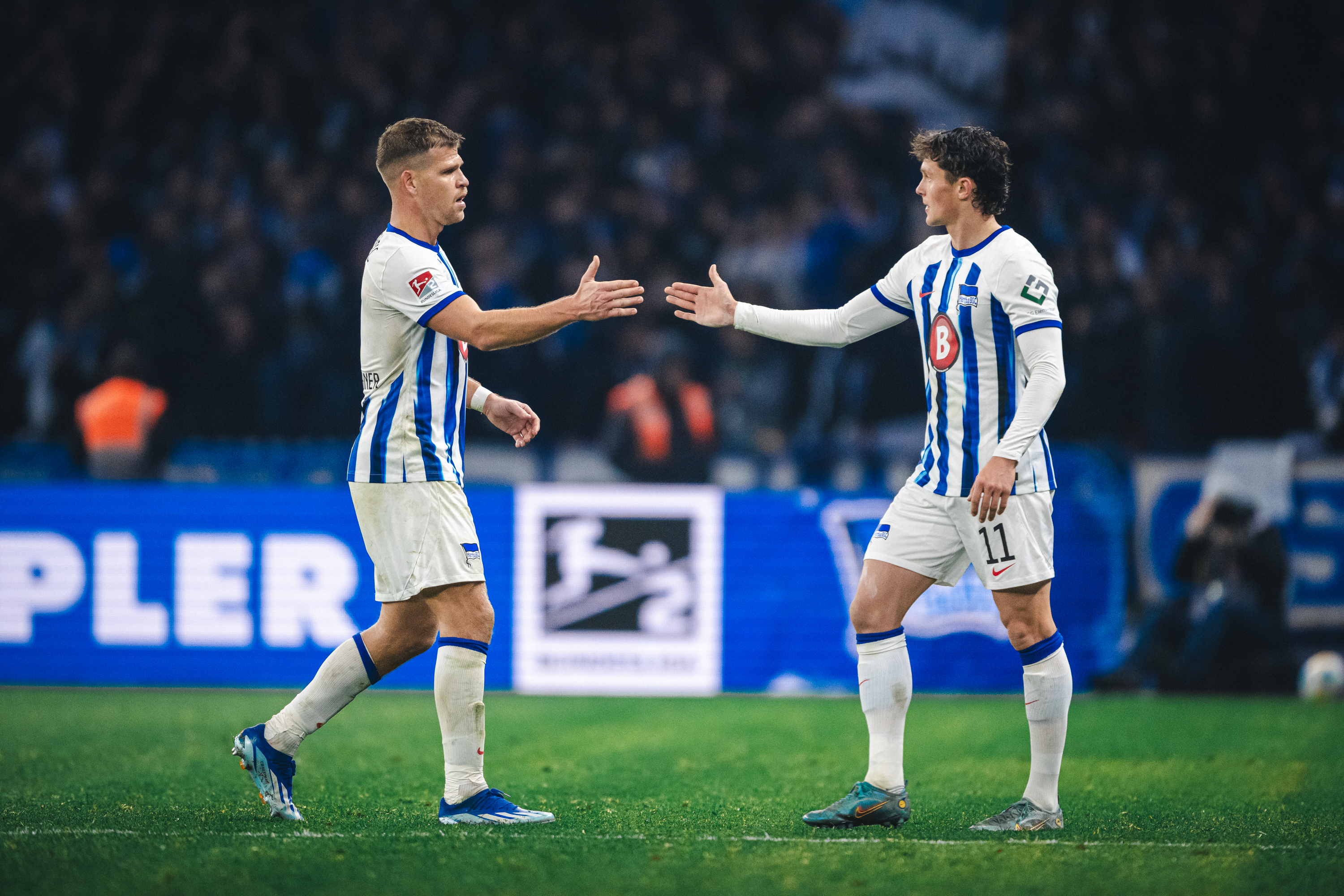 Florian Niederlechner und Fabian Reese klatschen im Spiel gegen den KSC ab.