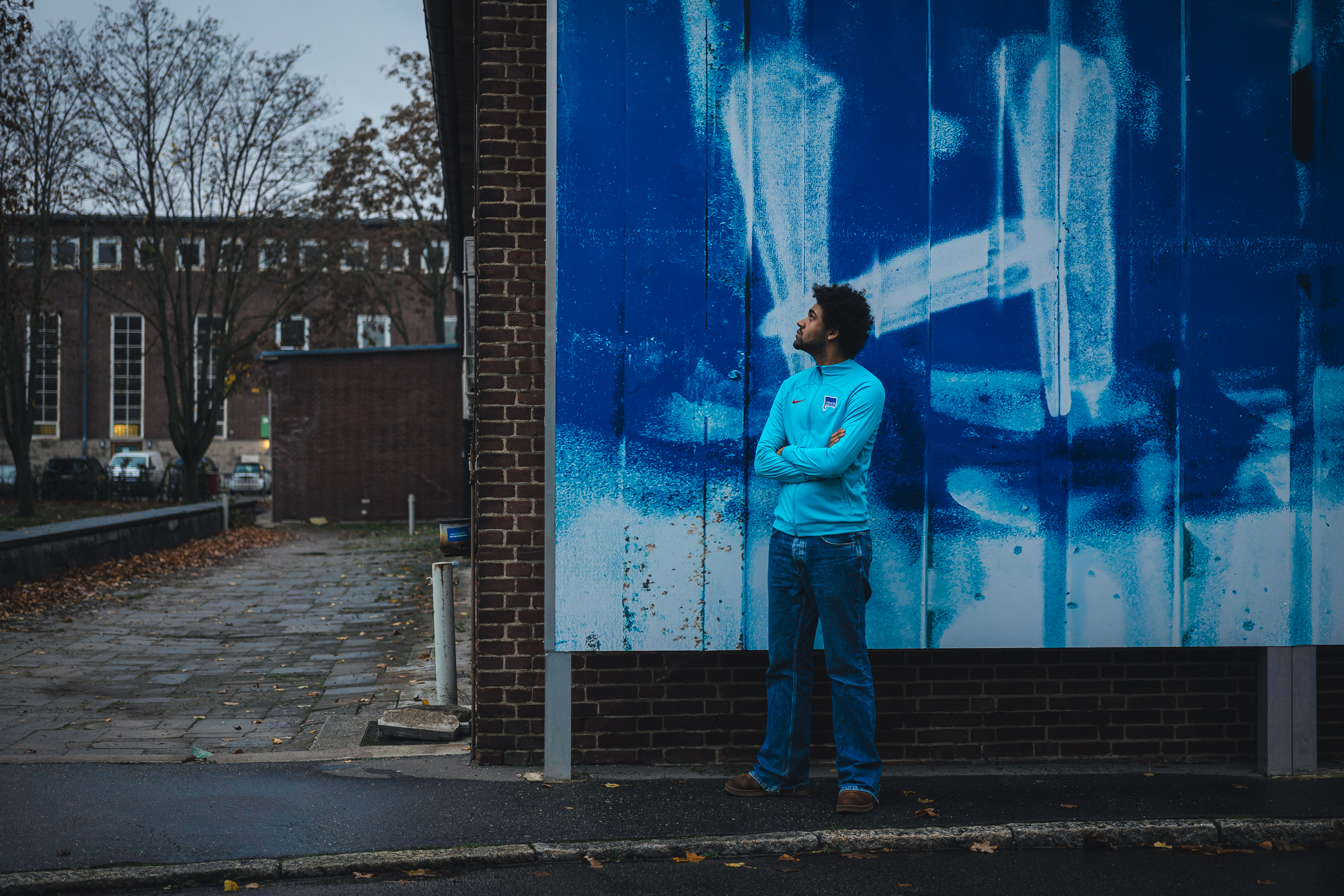 Langston Uibel blickt auf die Hertha-Wand vor der Geschäftsstelle.