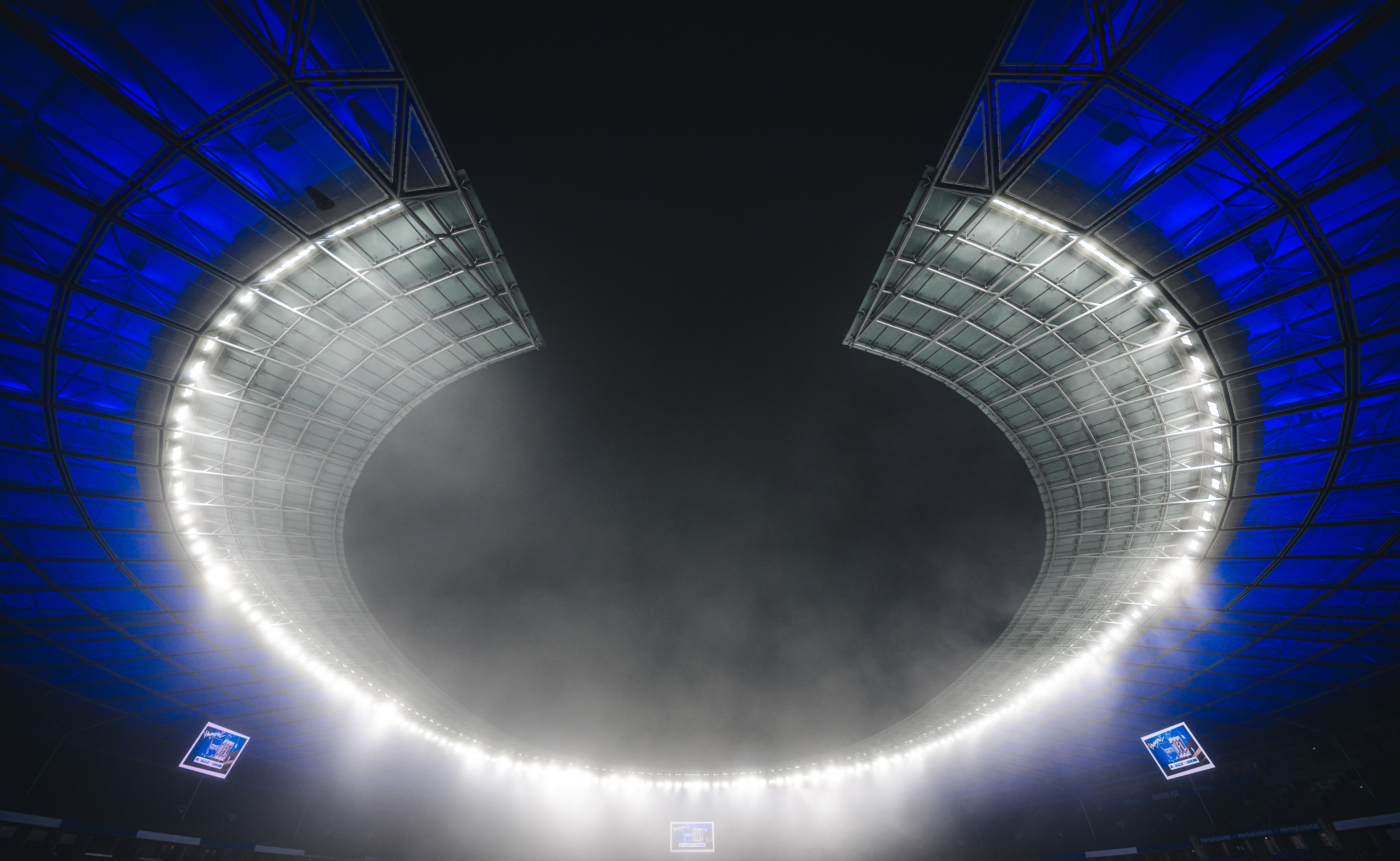 Das blau-weiße Dach des Berliner Olympiastadions bei Nacht.