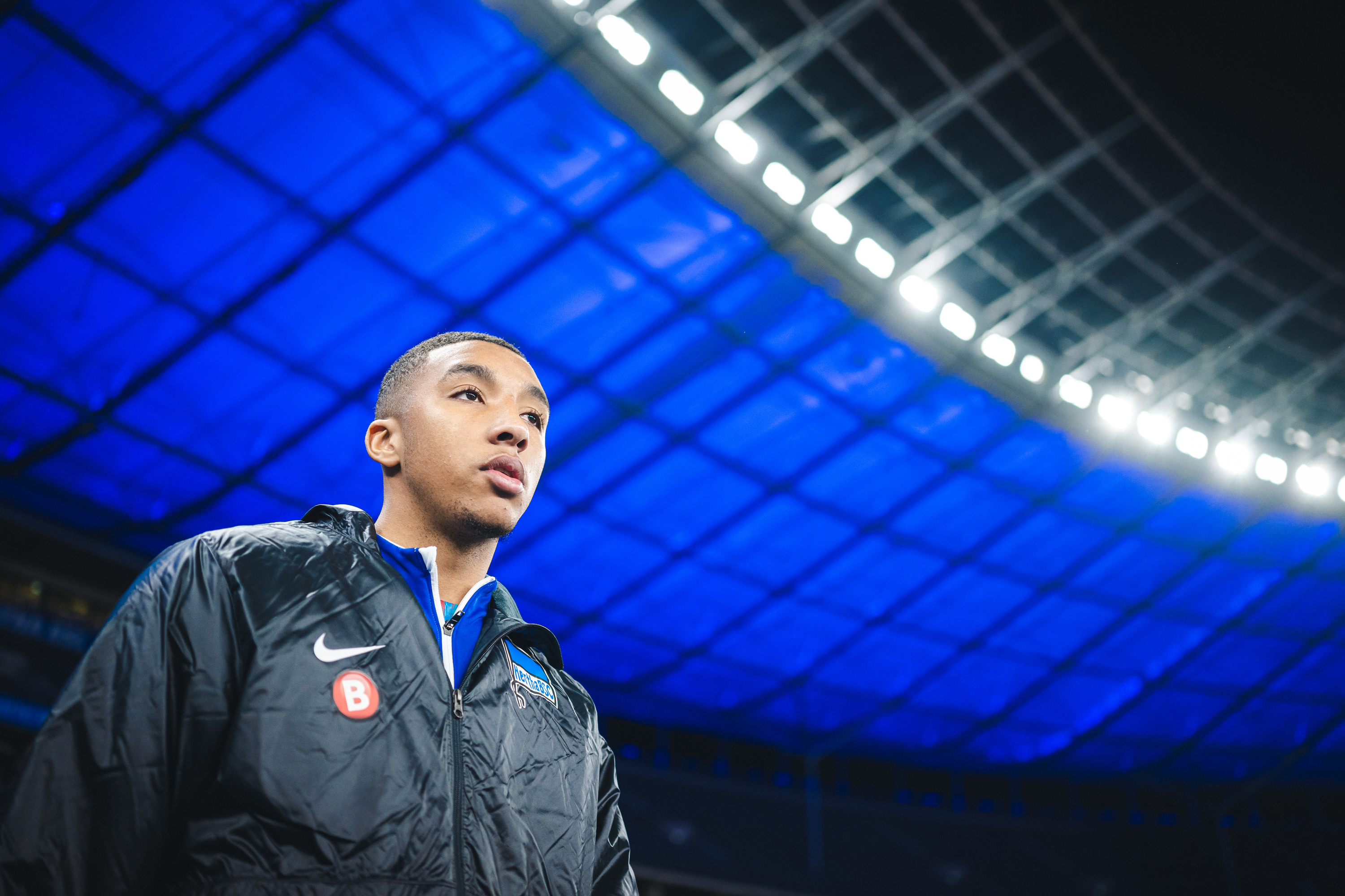 Bradley Ibrahim tritt in das Blau leuchtende Olympiastadion ein.