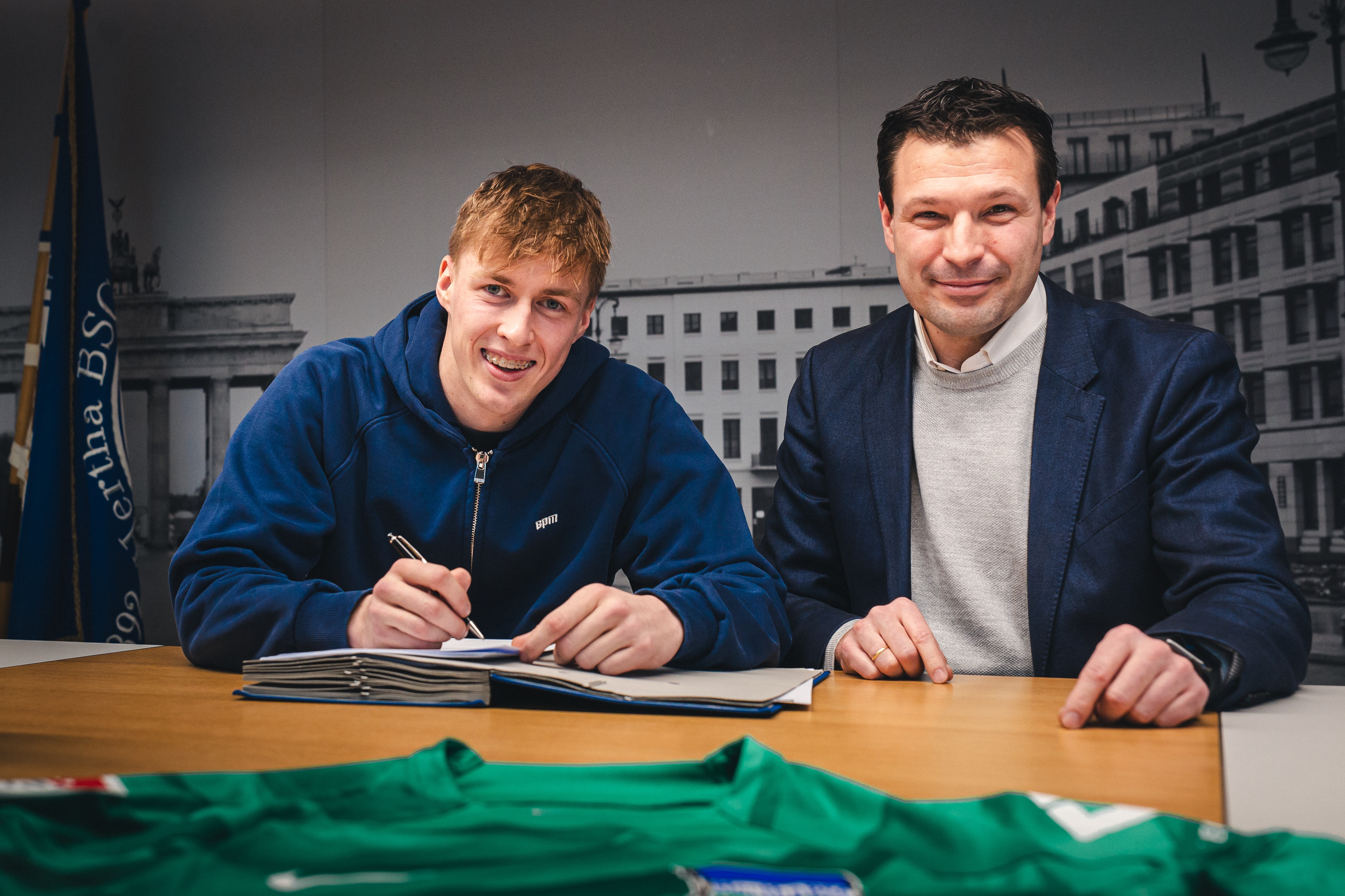 Tim Goller signs his new contract alongside Benjamin Weber.