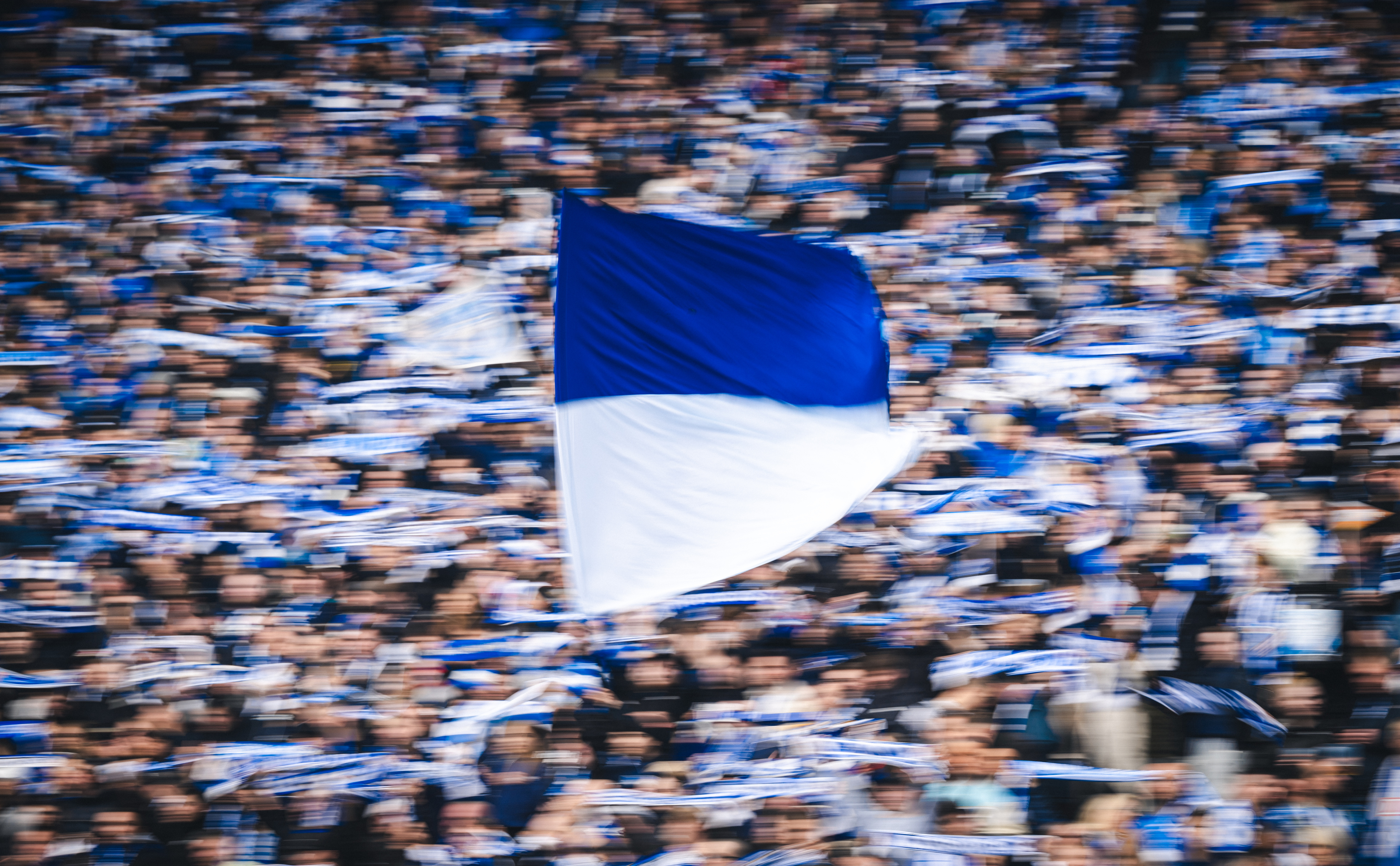 A blue and white flag in the Hertha end